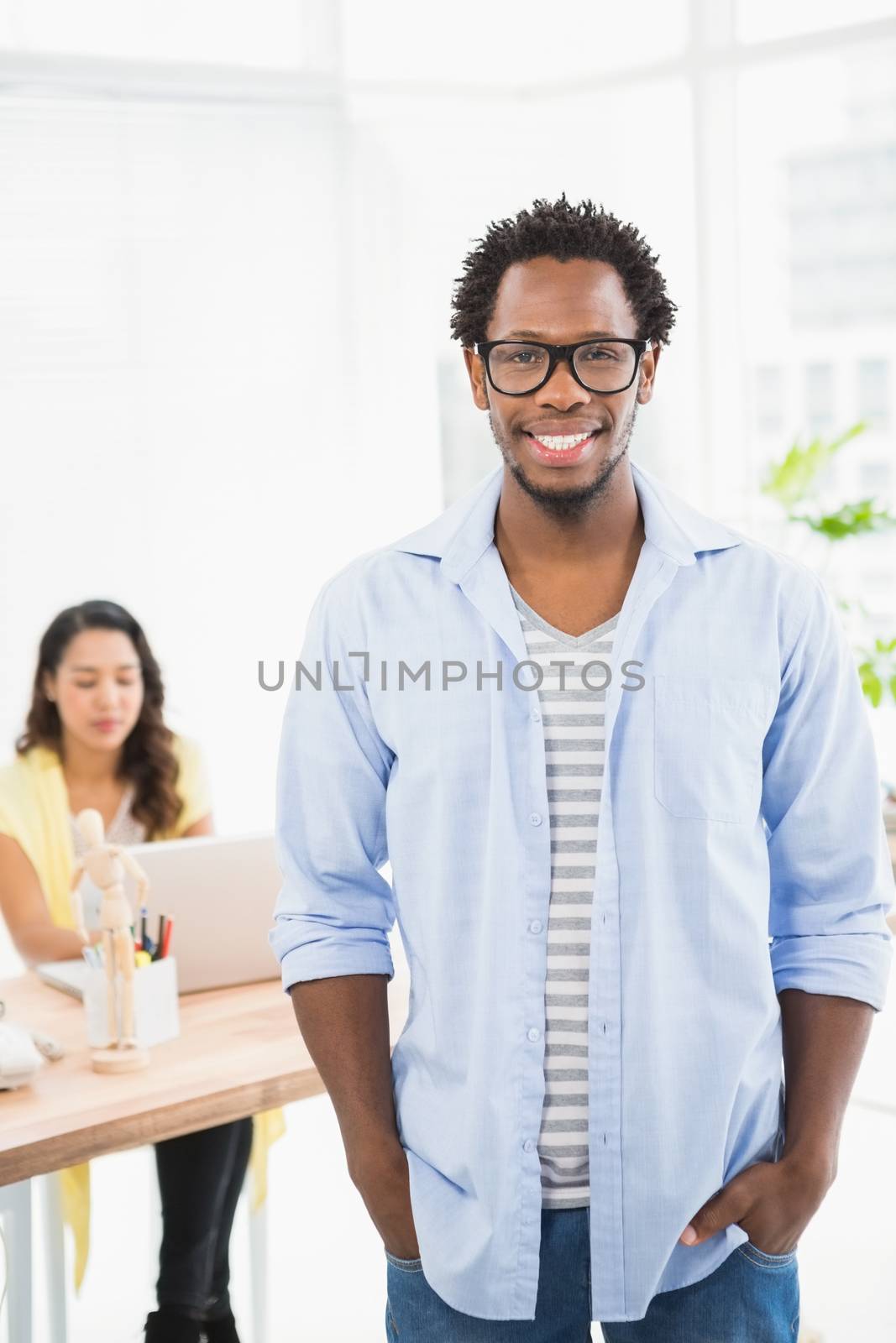 Smiling man posing in front of his colleague by Wavebreakmedia