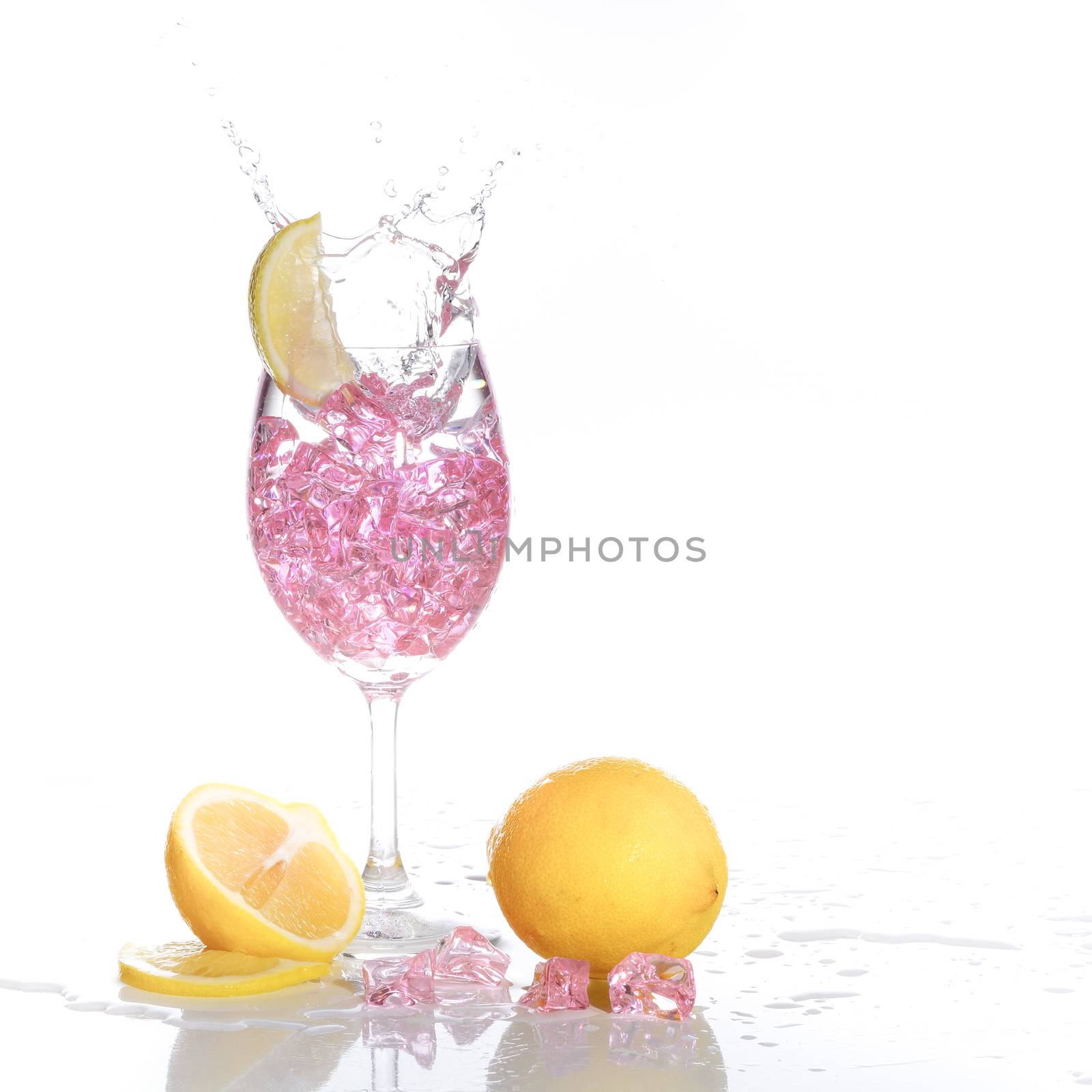 Stemmed champagne glass with lime liquor splashing out, isolated on white background