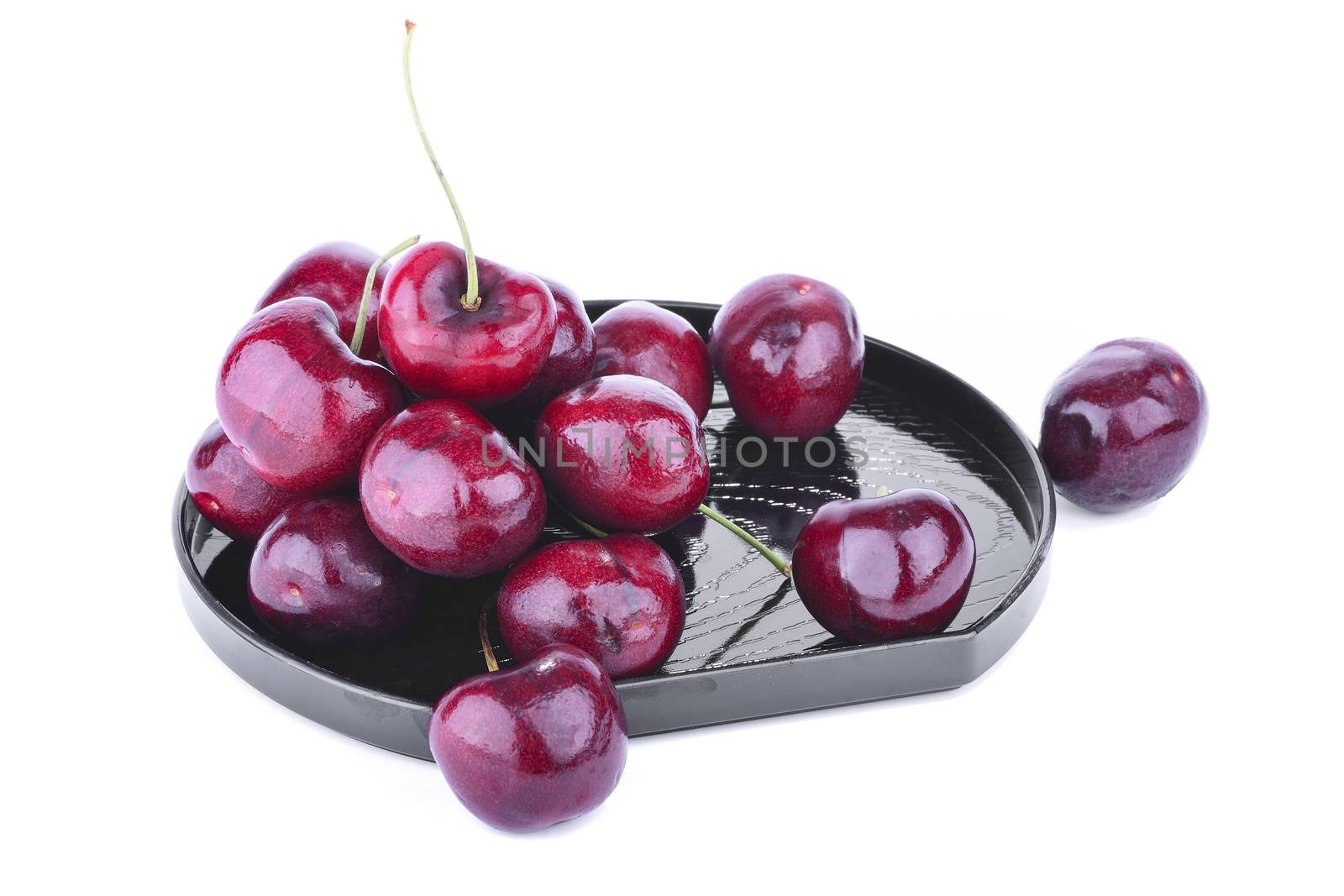 Ripe purple cherry on plate, isolated on white background