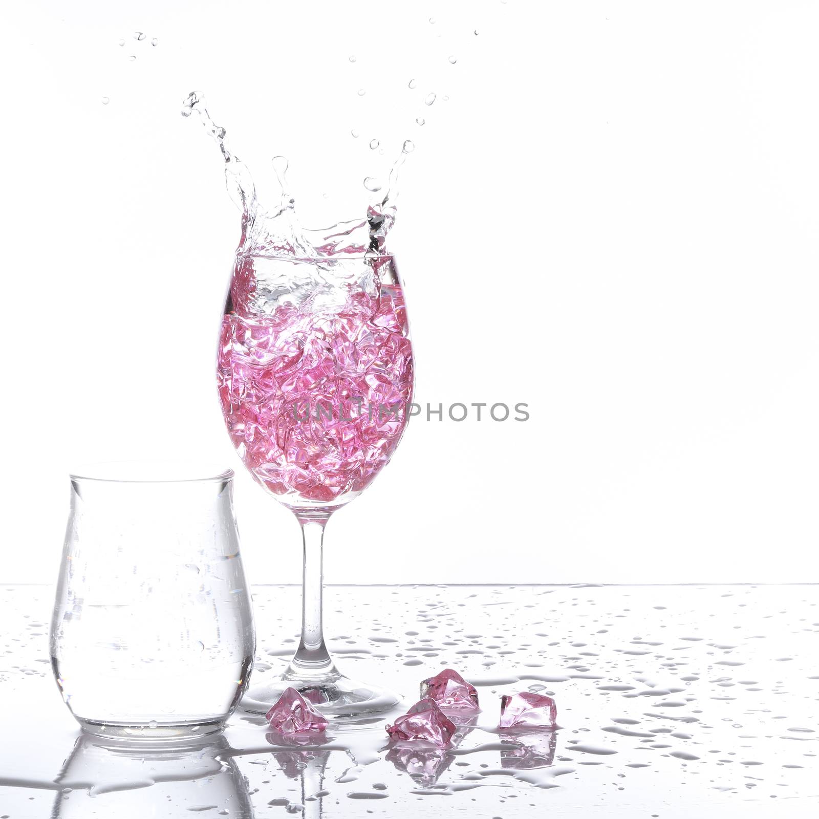 Stemmed champagne glass with liquor splashing out, isolated on white background