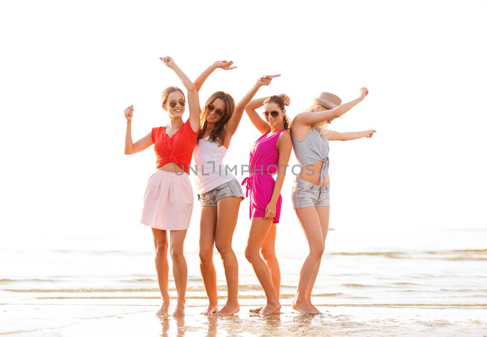 group of smiling women dancing on beach by dolgachov