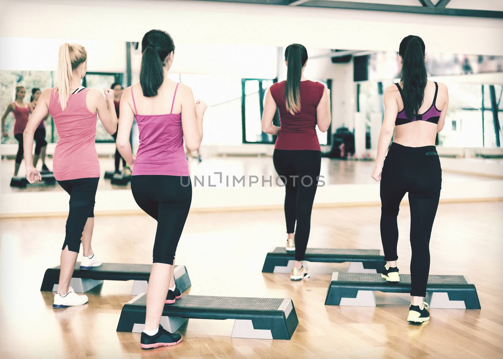 fitness, sport, training, gym and lifestyle concept - group of smiling people doing aerobic