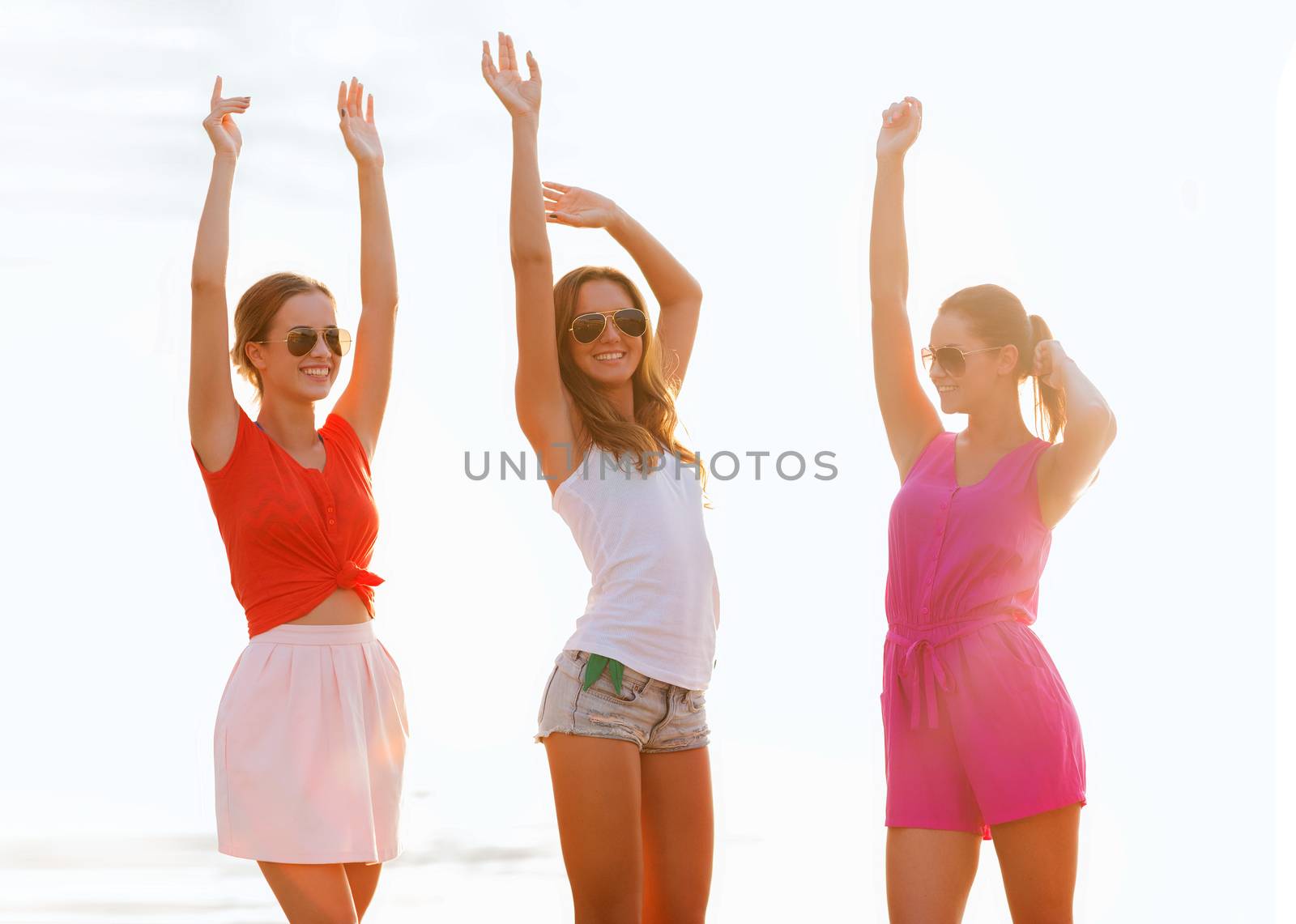 group of smiling women dancing on beach by dolgachov