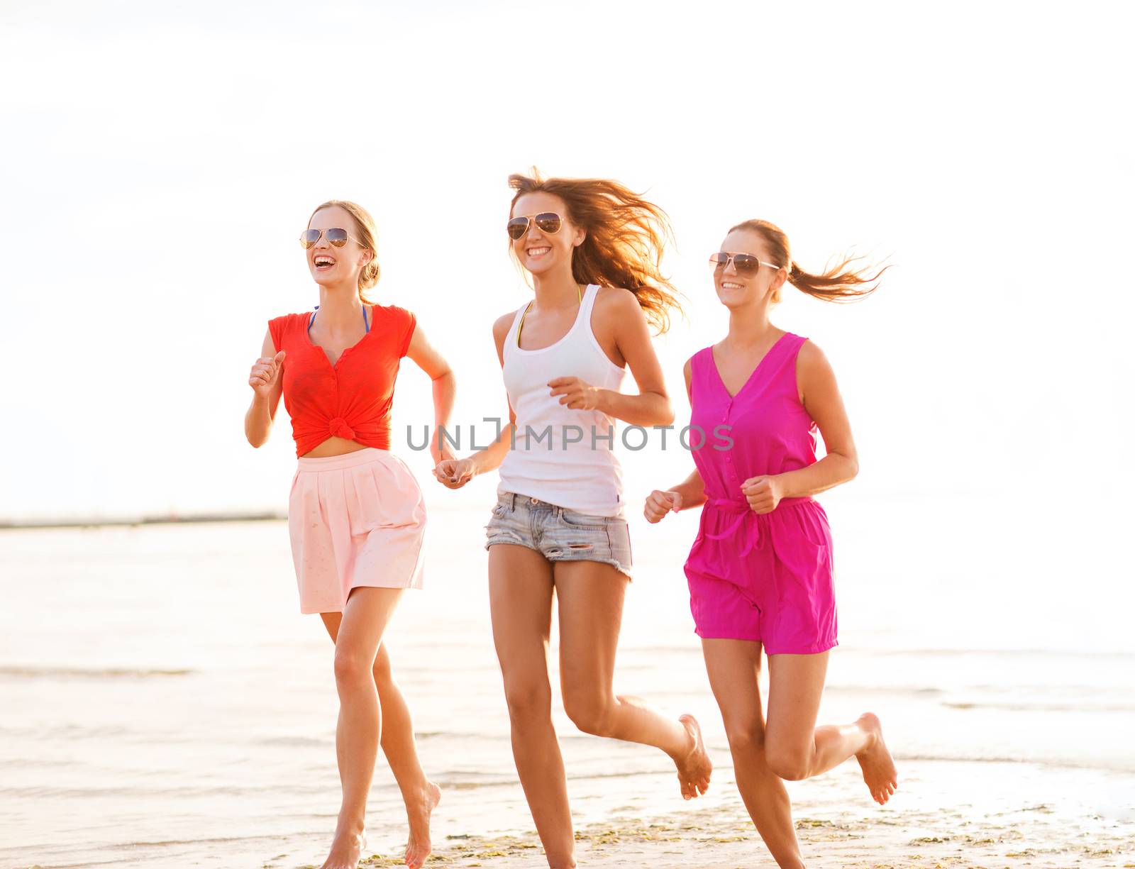 group of smiling women running on beach by dolgachov