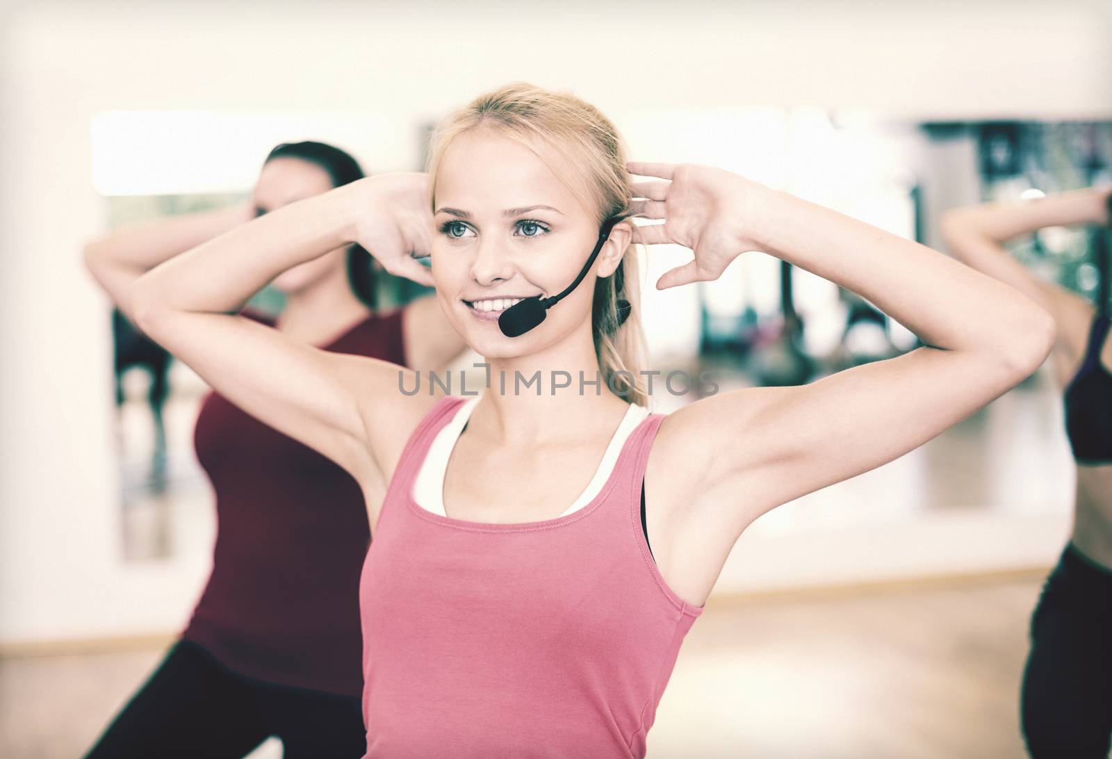 group of smiling people exercising in the gym by dolgachov