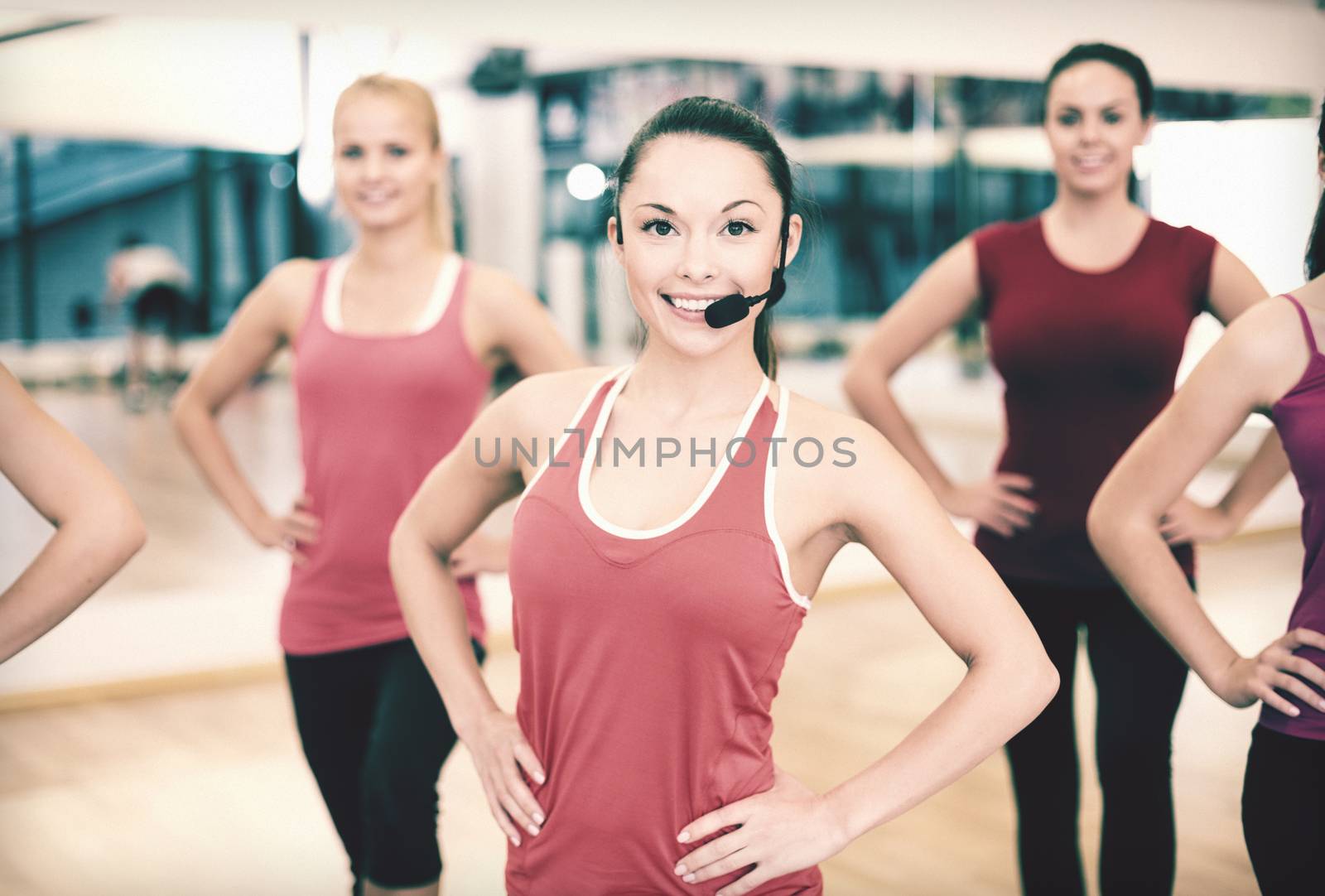 fitness, sport, training, gym and lifestyle concept - group of smiling people with trainer exercising in the gym