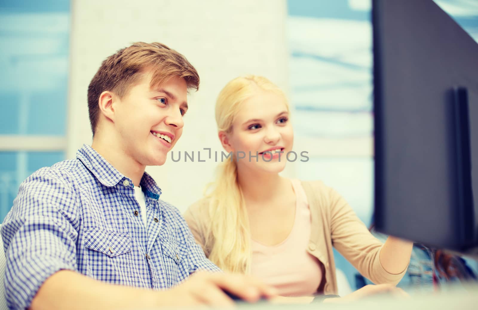 technology, school and education concept - smiling teenage boy and girl in computer class at school