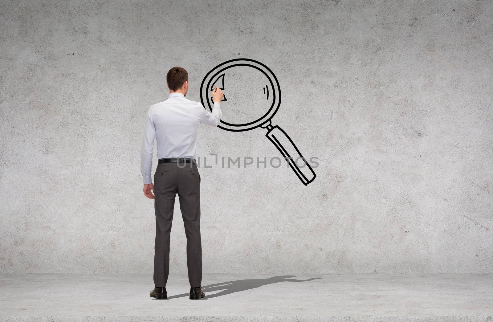 business, education and office people people concept - businessman with marker drawing magnifying glass over concrete wall background from back