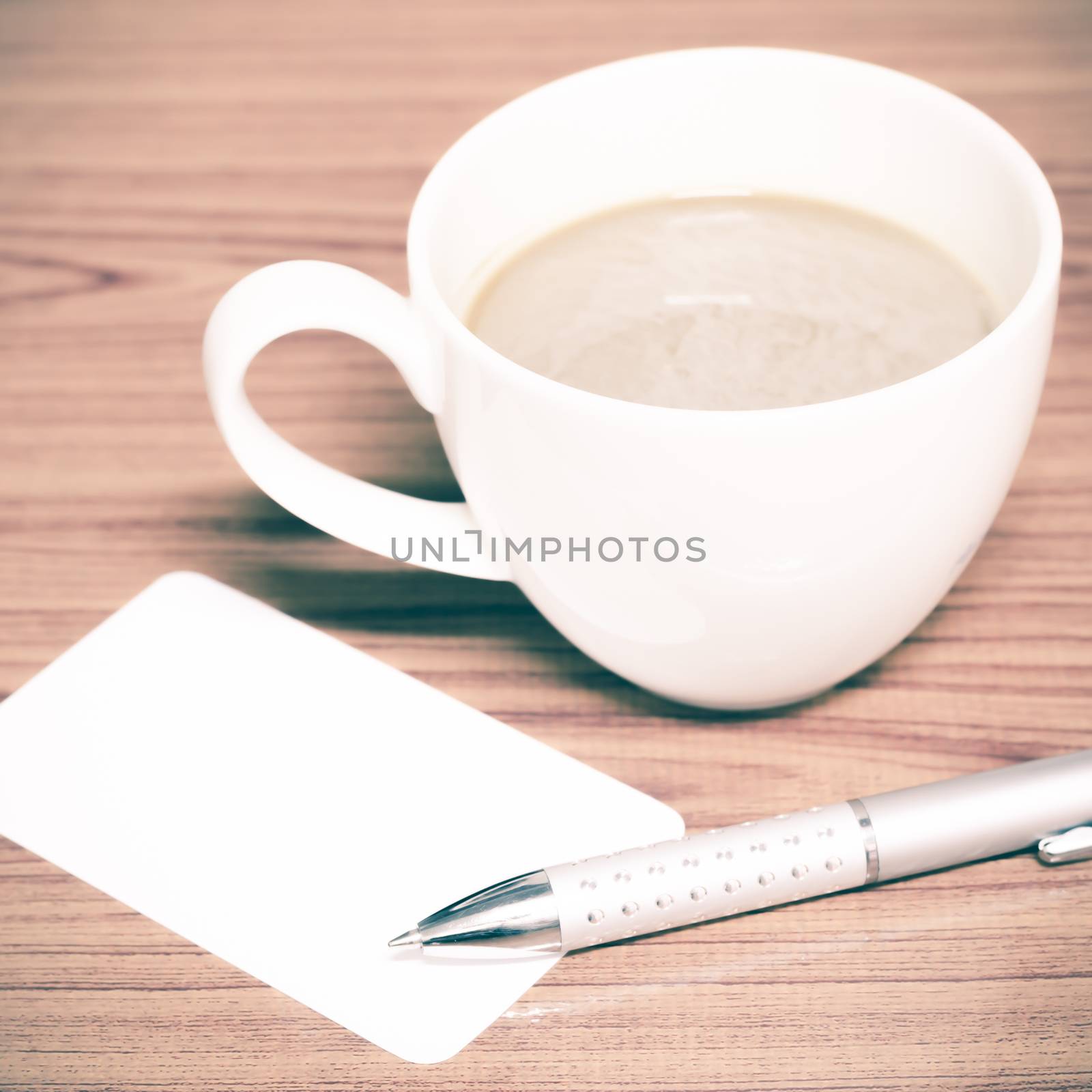 coffee cup and business card on wood background vintage style