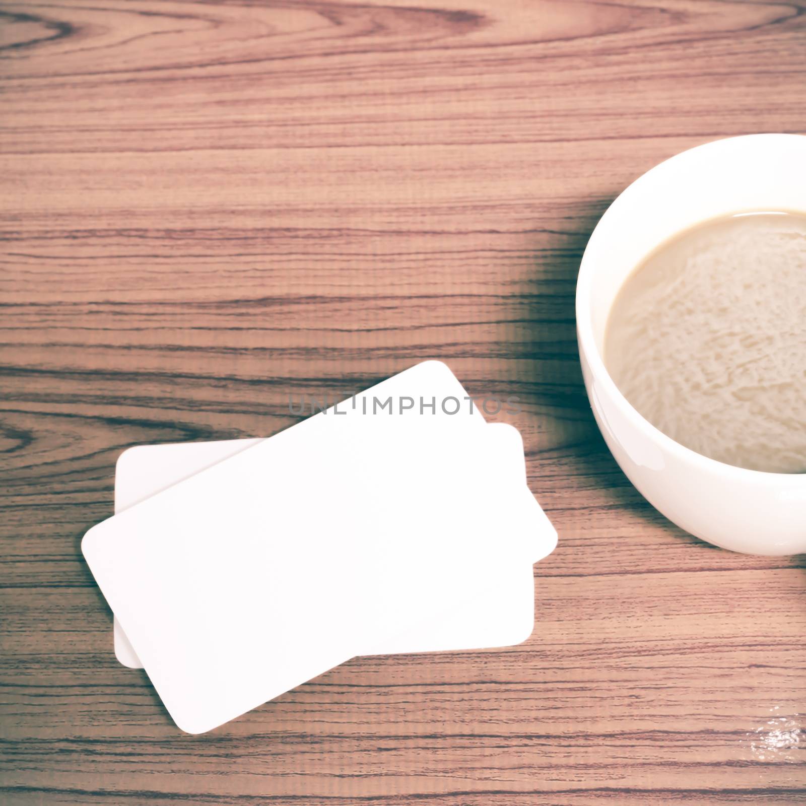 coffee cup and business card on wood background vintage style