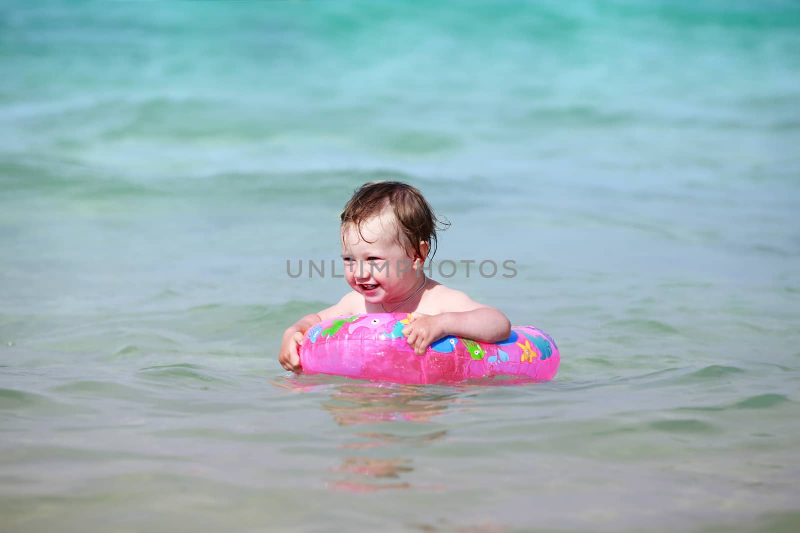 Little girl with rubber ring in the sea