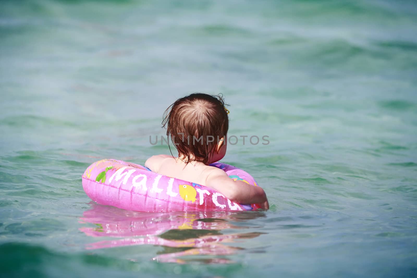 Little girl with rubber ring in the sea