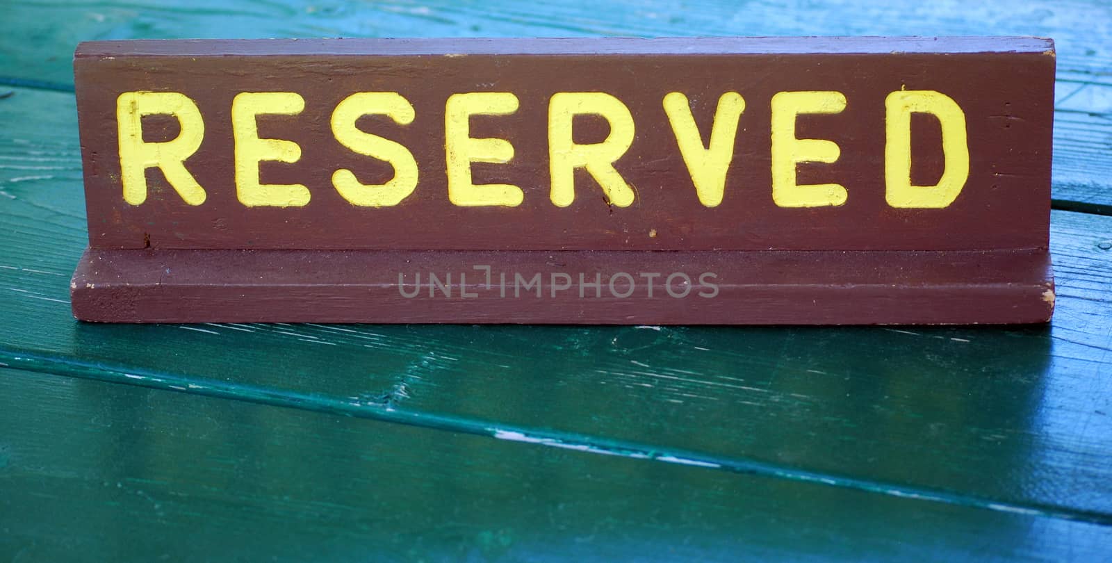 Reserved wooden sign on a campground site table outdoors.