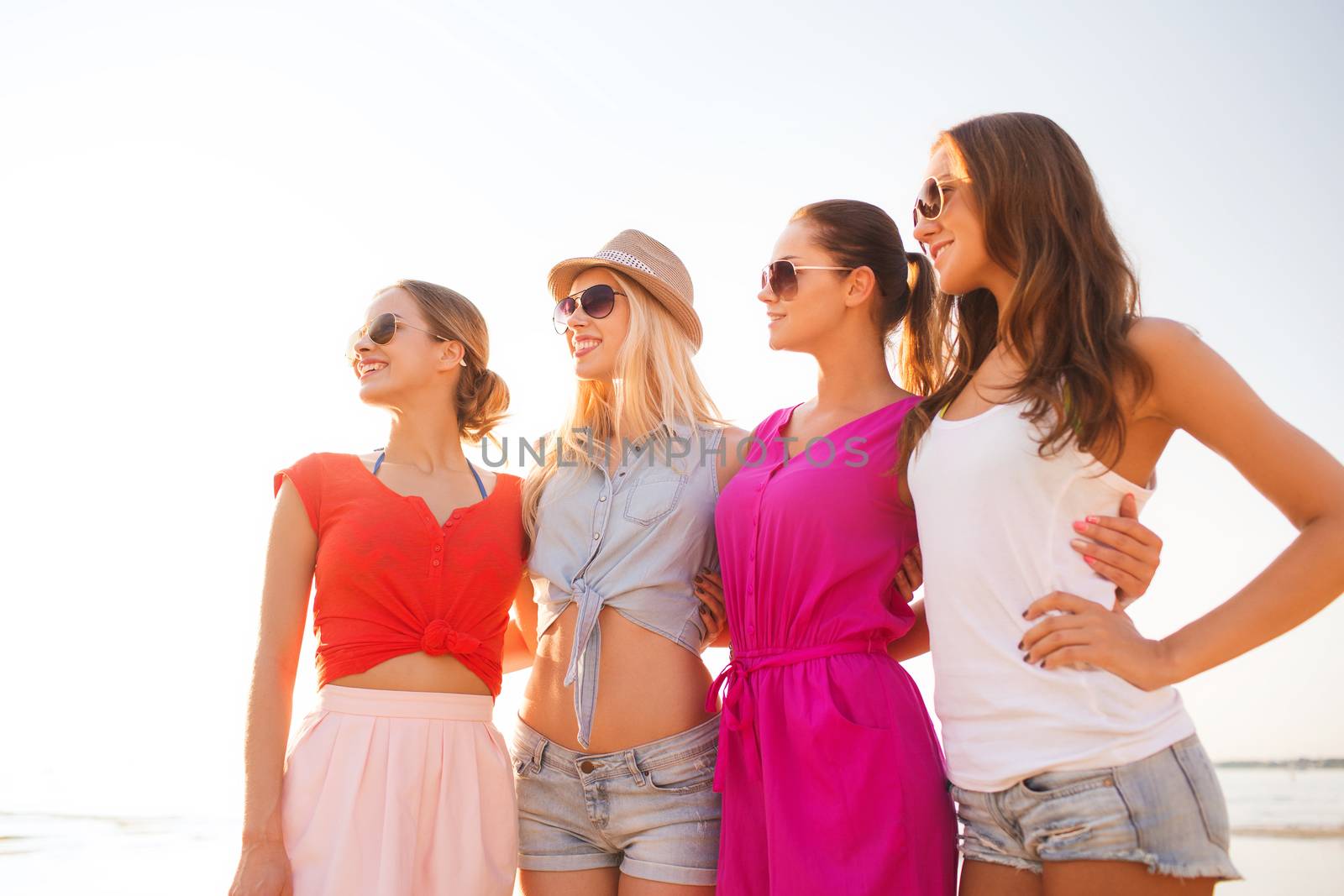 group of smiling women in sunglasses on beach by dolgachov