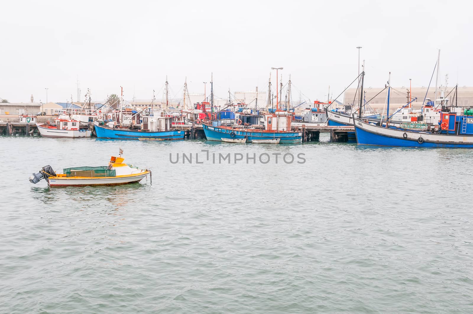 LUDERITZ, NAMIBIA - JUNE 14, 2011: Fishing boats at the harbor in Luderitz on a gloomy day. The small town is known for its crayfish inustry