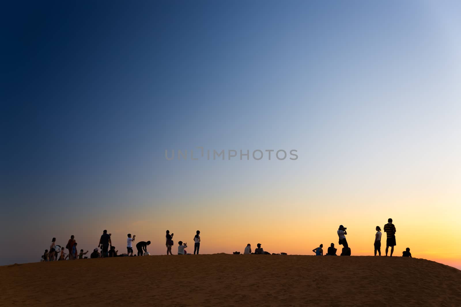 MUI NE, VIETNAM - FEBRUARY 08, 2014: Tourist watching sunset on  by fisfra