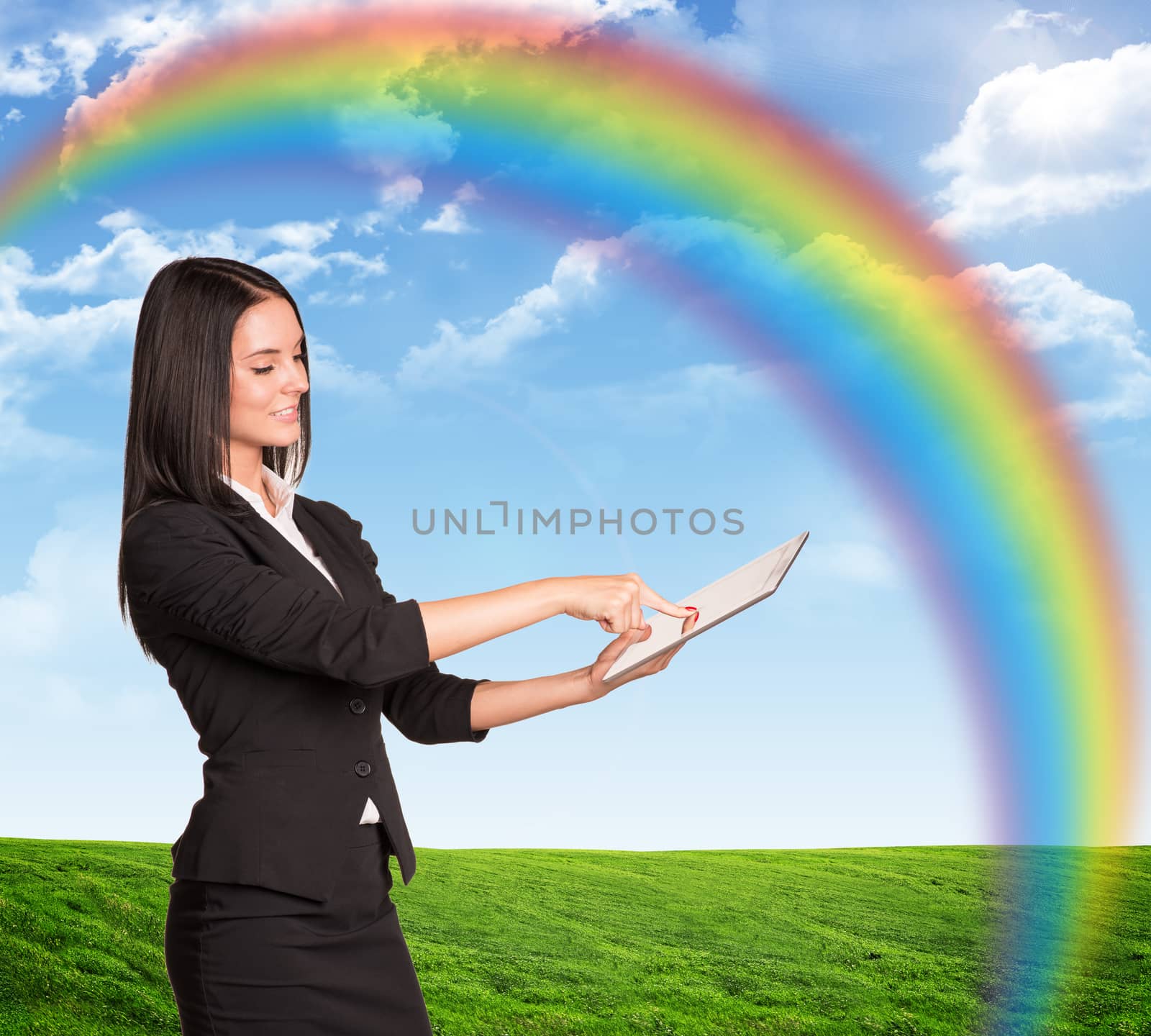 Businesswoman using tablet on nature background with rainbow