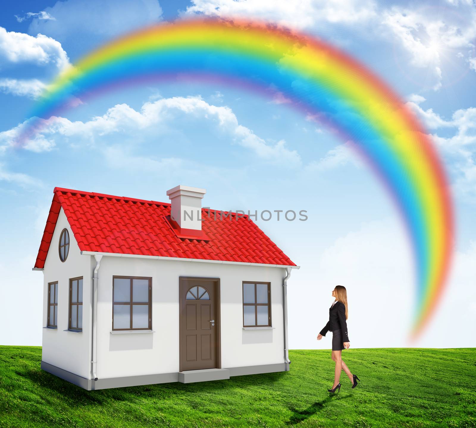 Businesswoman going to house with rainbow and lawn