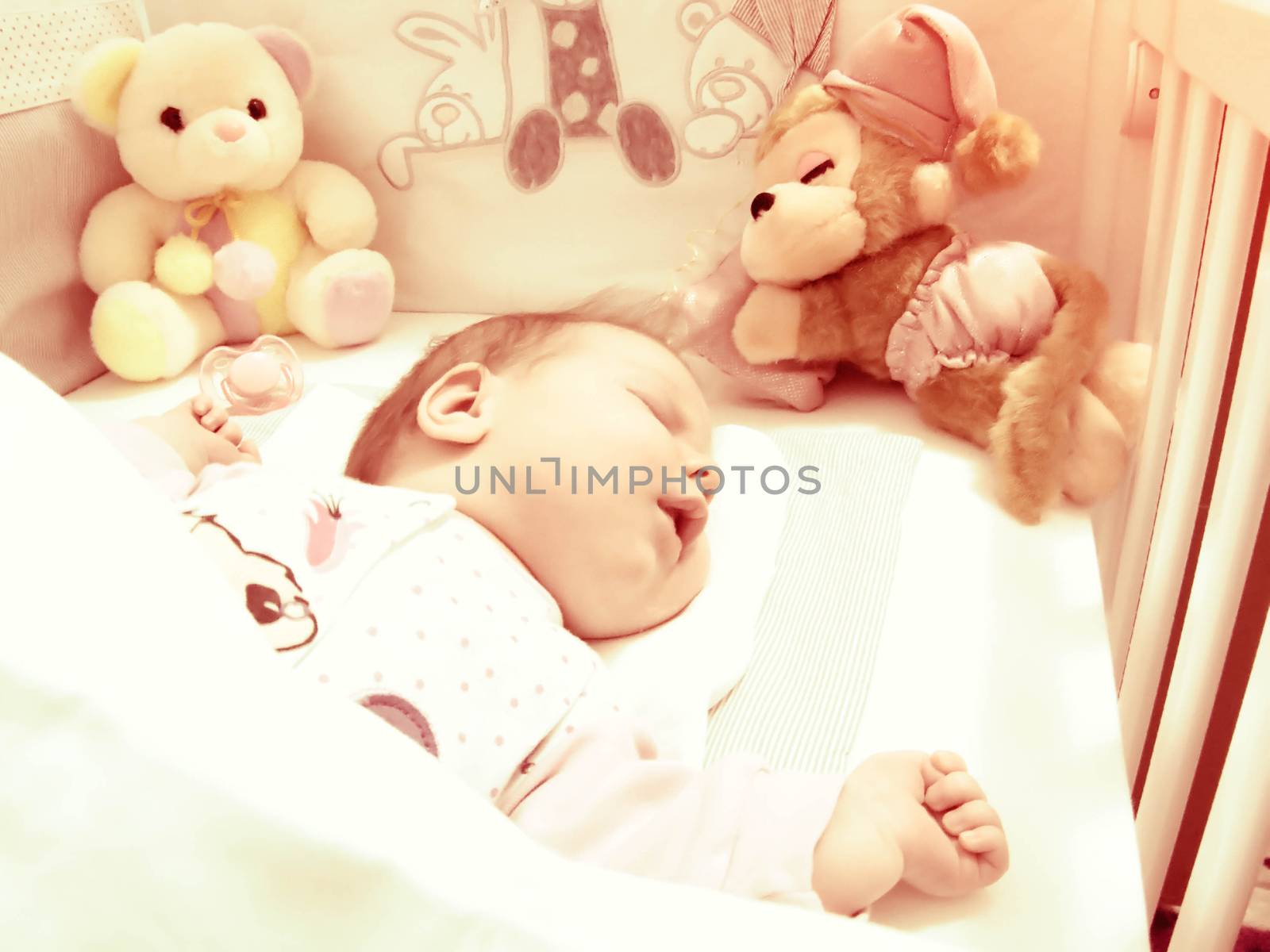 Newborn baby sleeping with toys by fadeinphotography