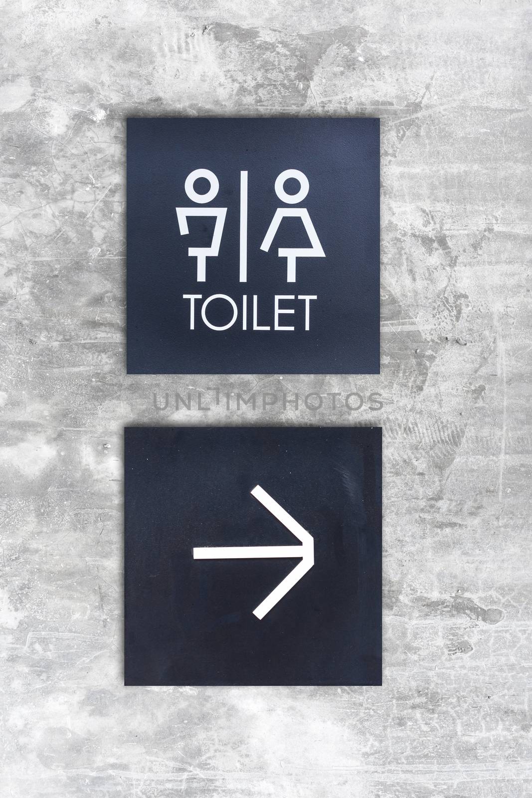 Unisex restroom or Toilet and arrow sign on concrete wall style boutique by nopparats