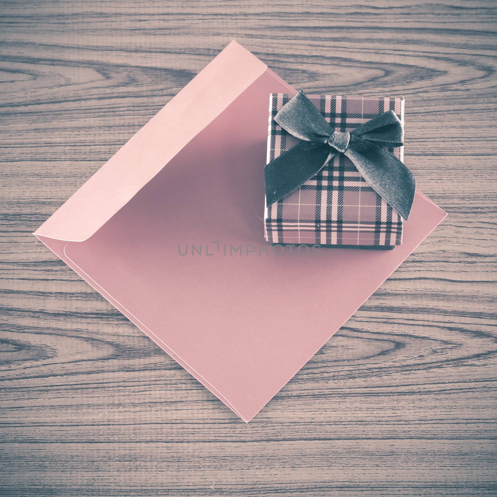 red gift box and envelope on wood background