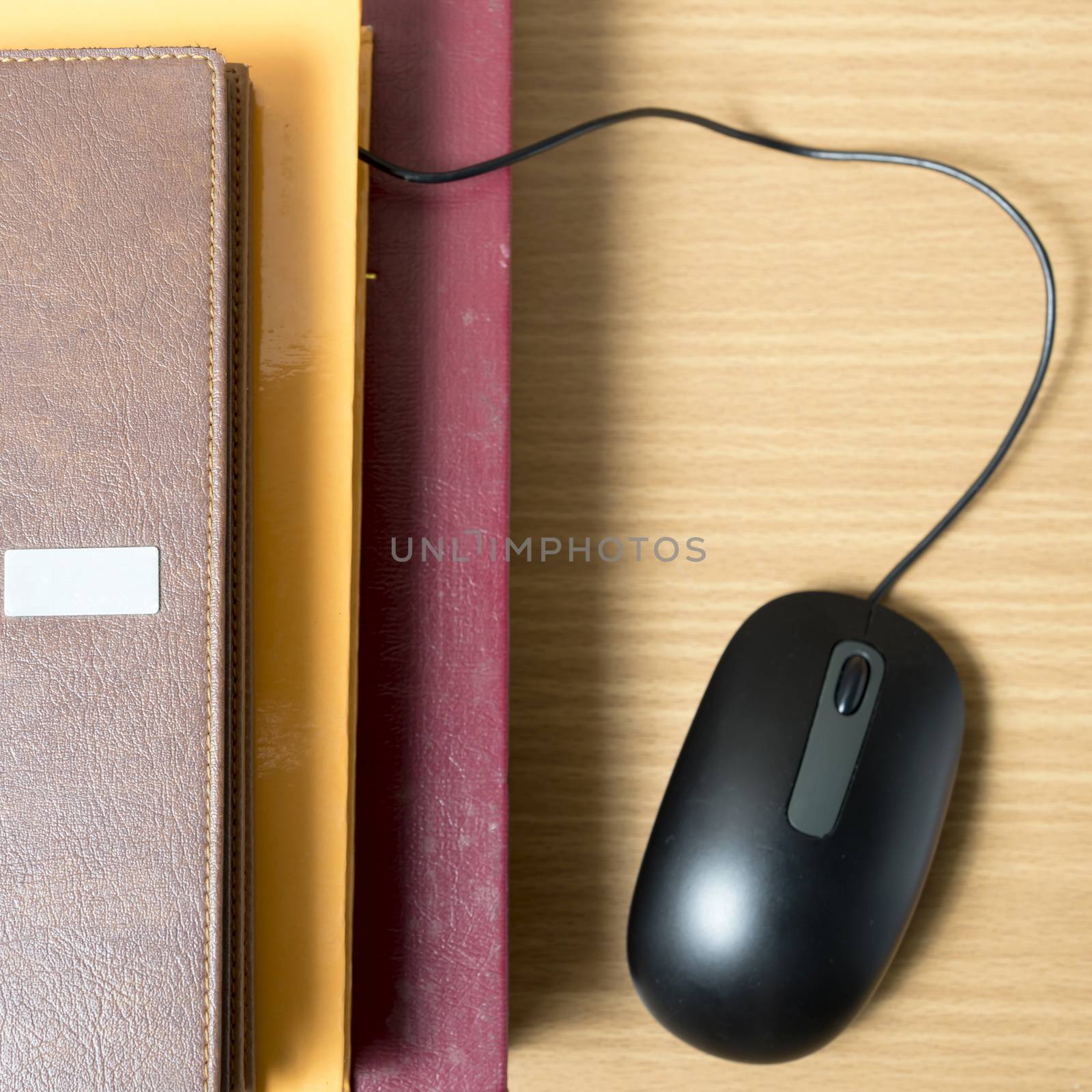 book and computer mouse on wood background