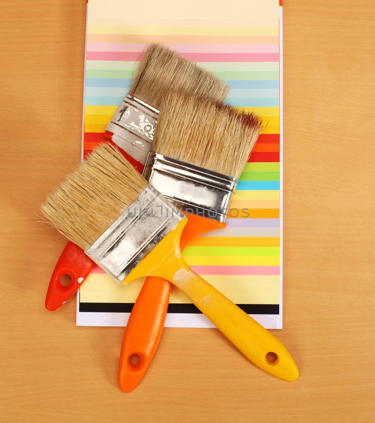 Three paint brushes on a colour guide. 