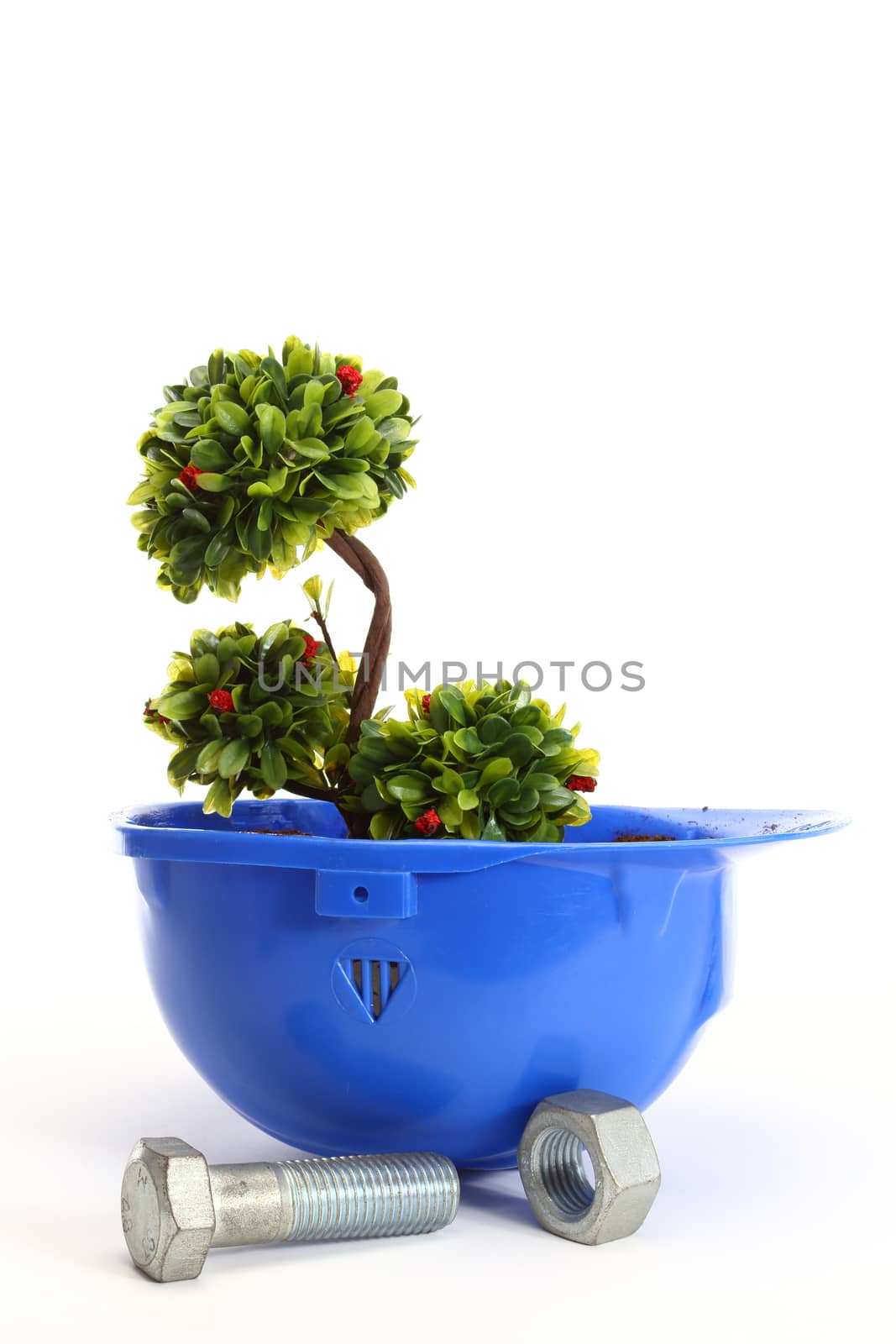 Green plant in blue helmet on white - environmental friendly industry concept