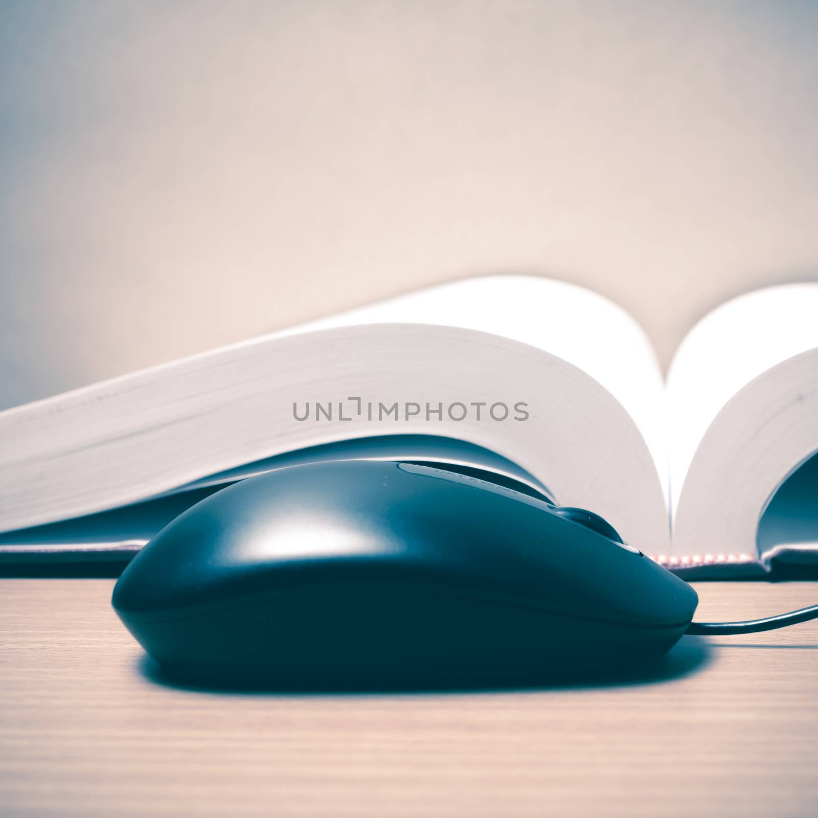 book and computer mouse on wood background vintage style