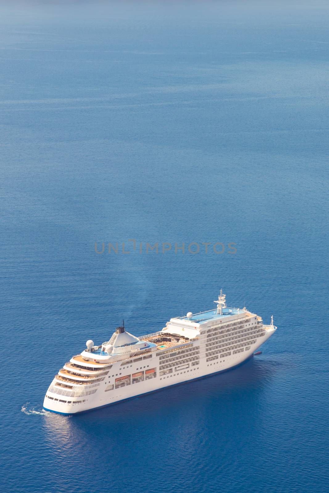 Luxury cruise ship sailing around Santorini island, Aegean sea in Greece.