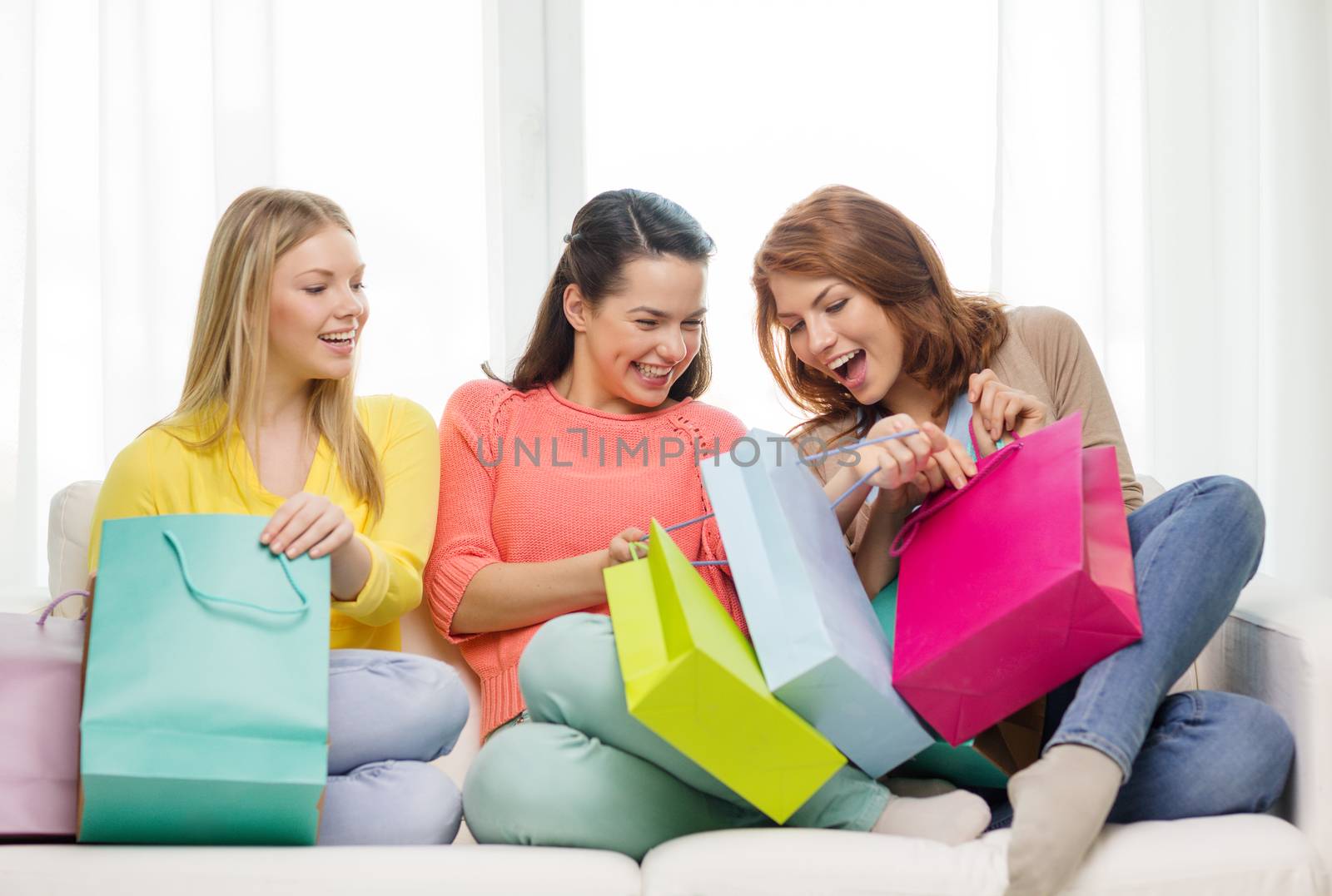 shopping and lifestyle concept - three smiling teenage girls with many shopping bags at home