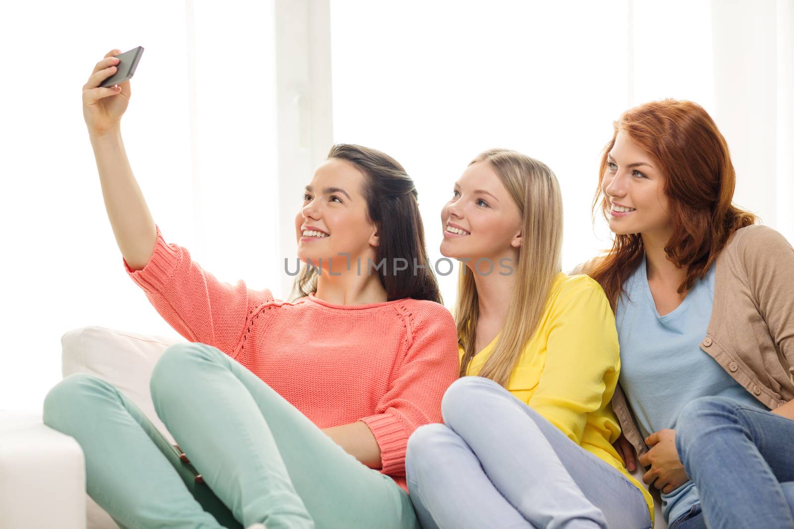 teenage girls taking selfie with smartphone by dolgachov