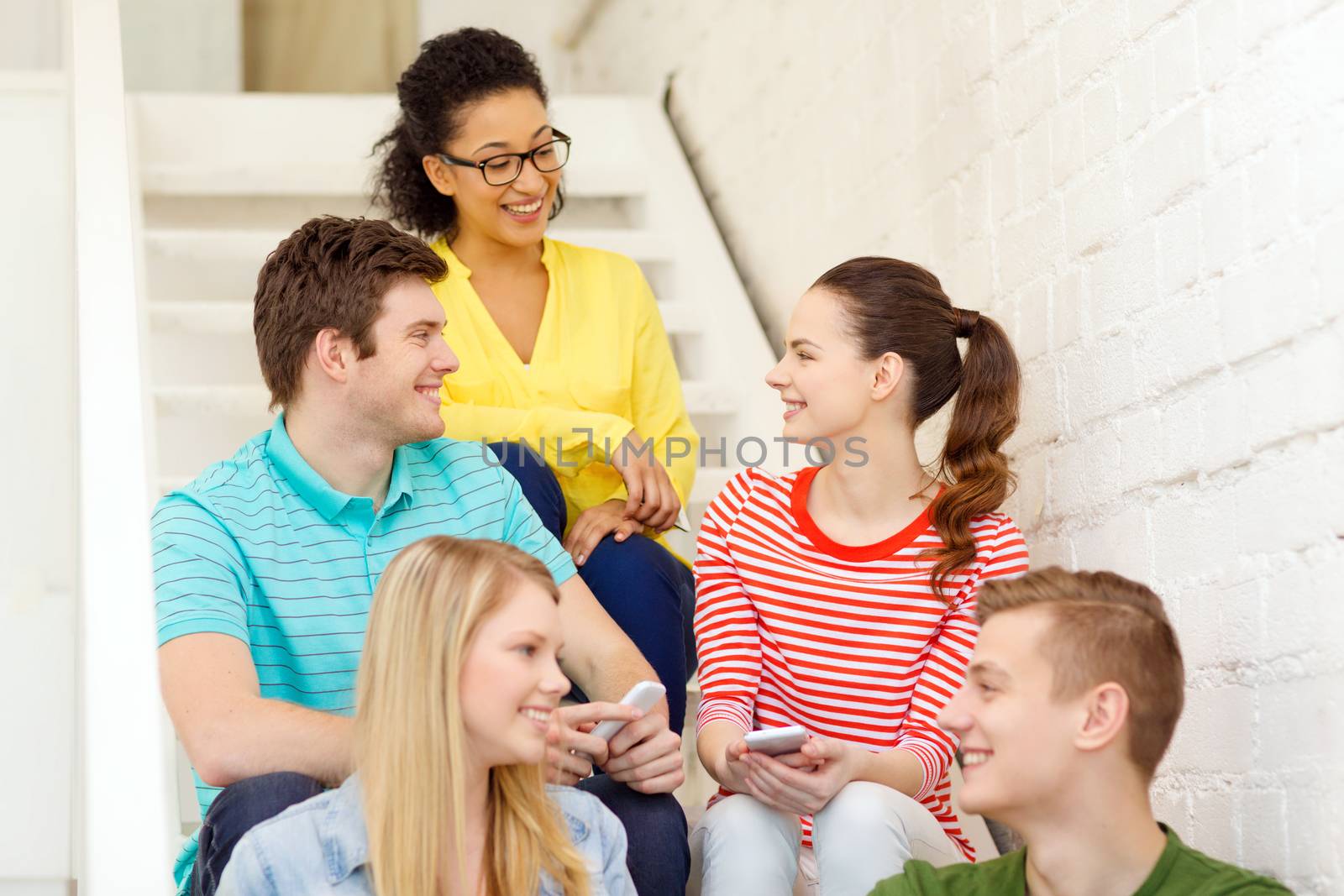 smiling students with smartphone having discussion by dolgachov
