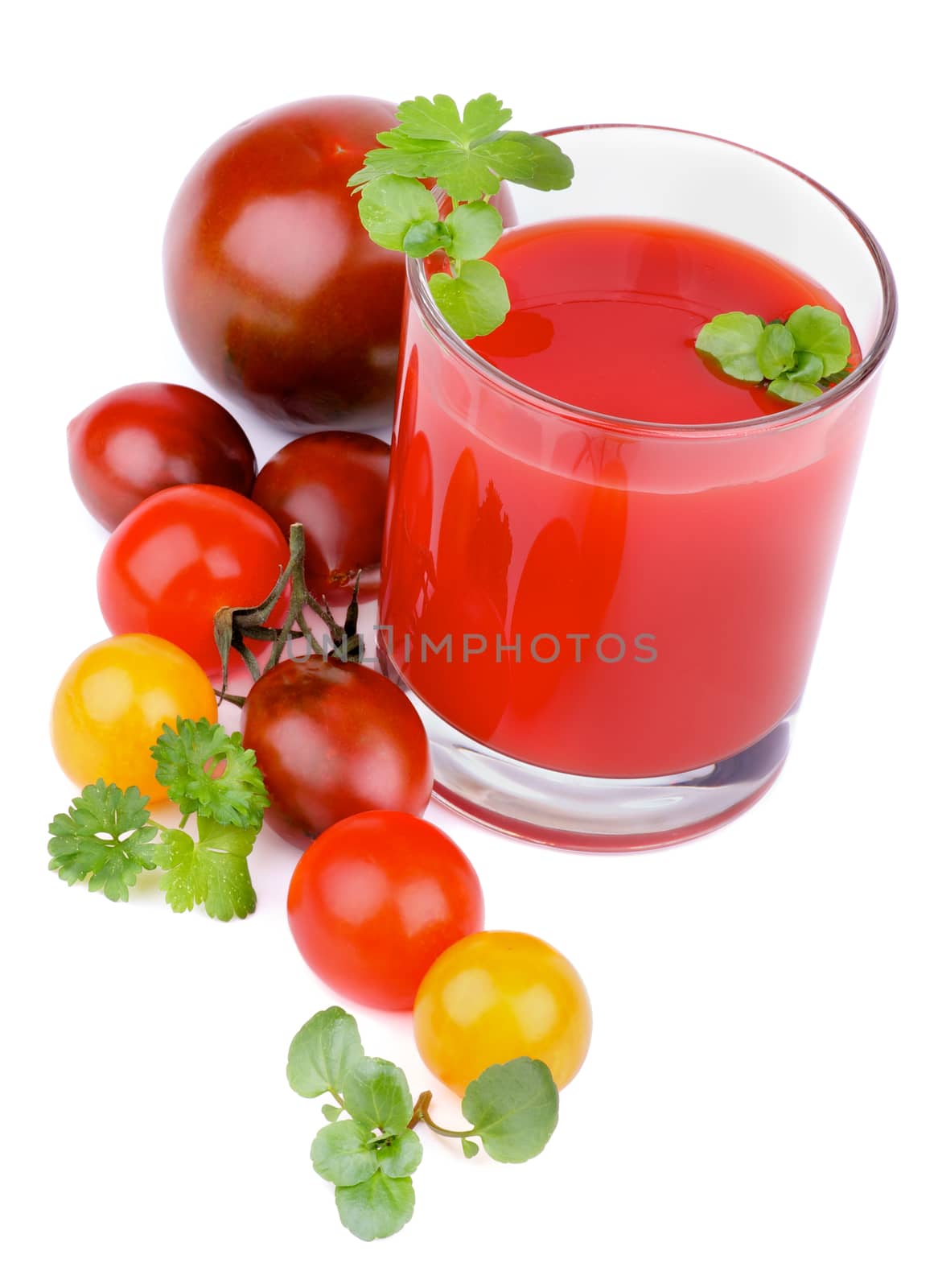 Arrangement of Glass with Tomato Juice and Brown, Yellow and Red Tomatoes with Greens isolated on White background