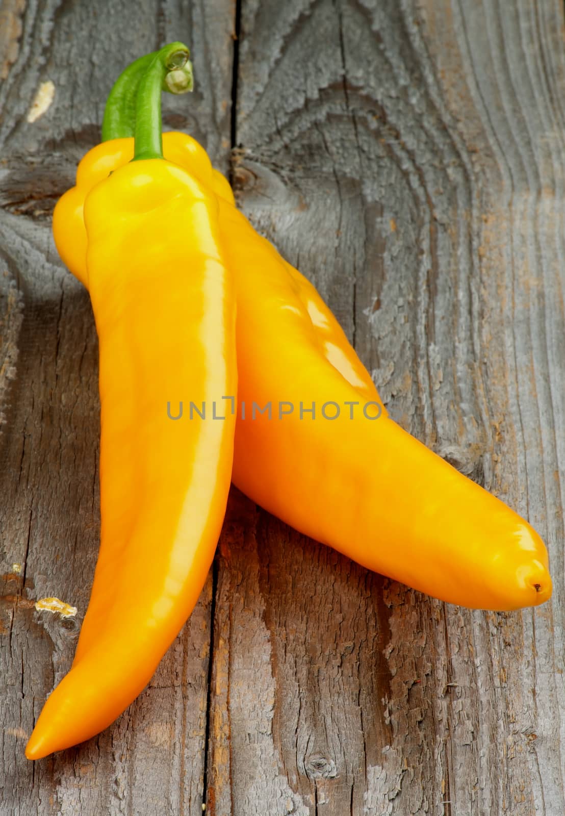 Raw Ripe Yellow Ramiro Peppers with Green Tails isolated on Rustic Wooden background