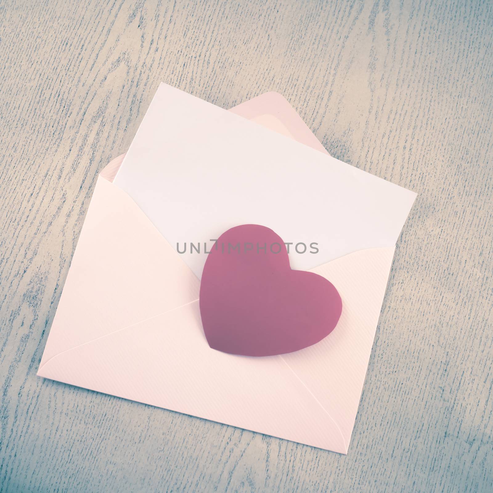 red heart with pink envelope on wooden background vintage style