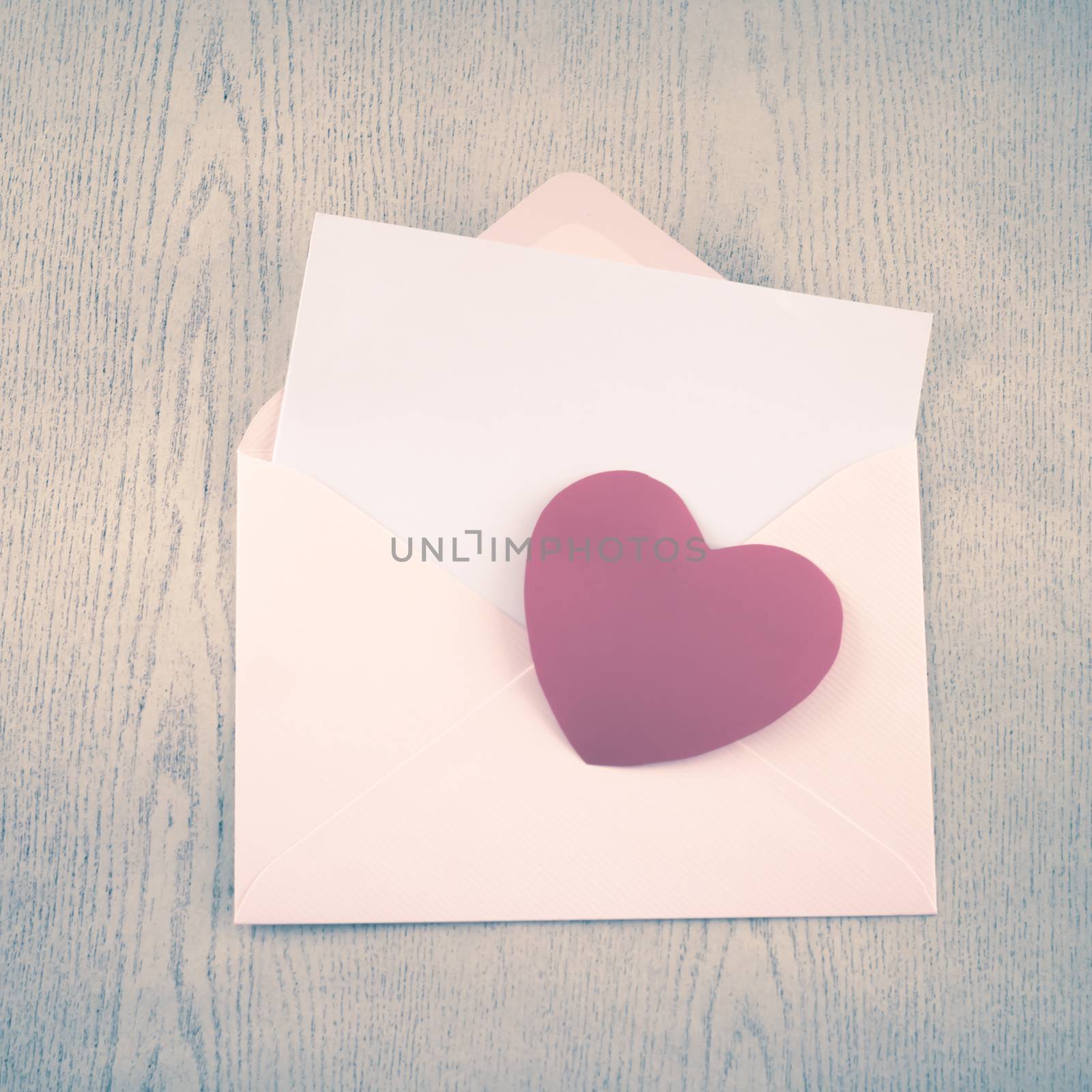 red heart with pink envelope on wooden background vintage style