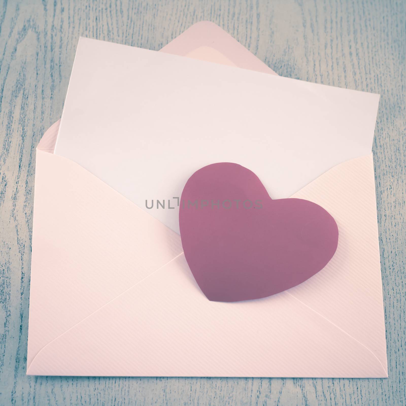 red heart with pink envelope on wooden background vintage style