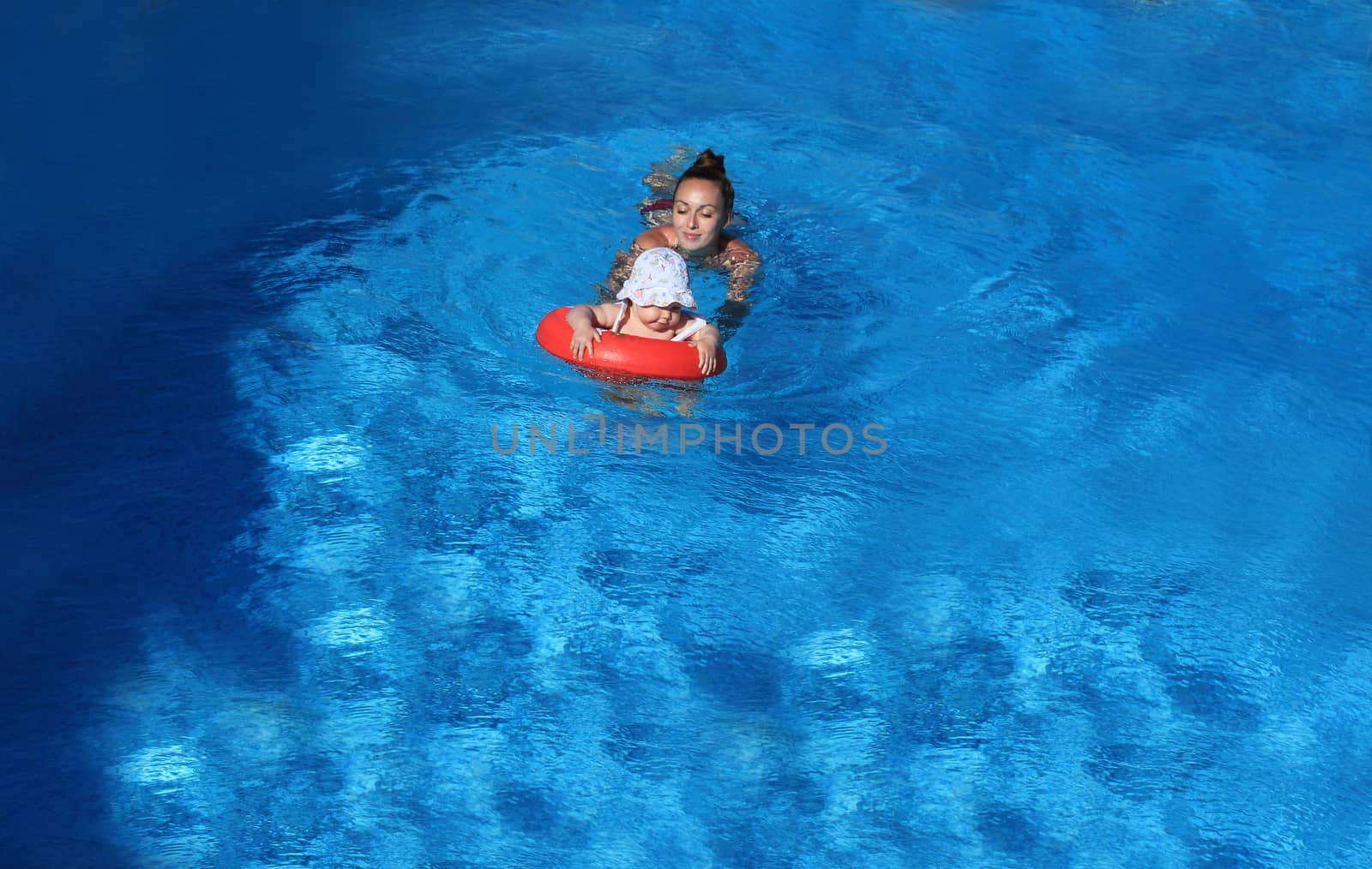Happy mother holding her daughter in water