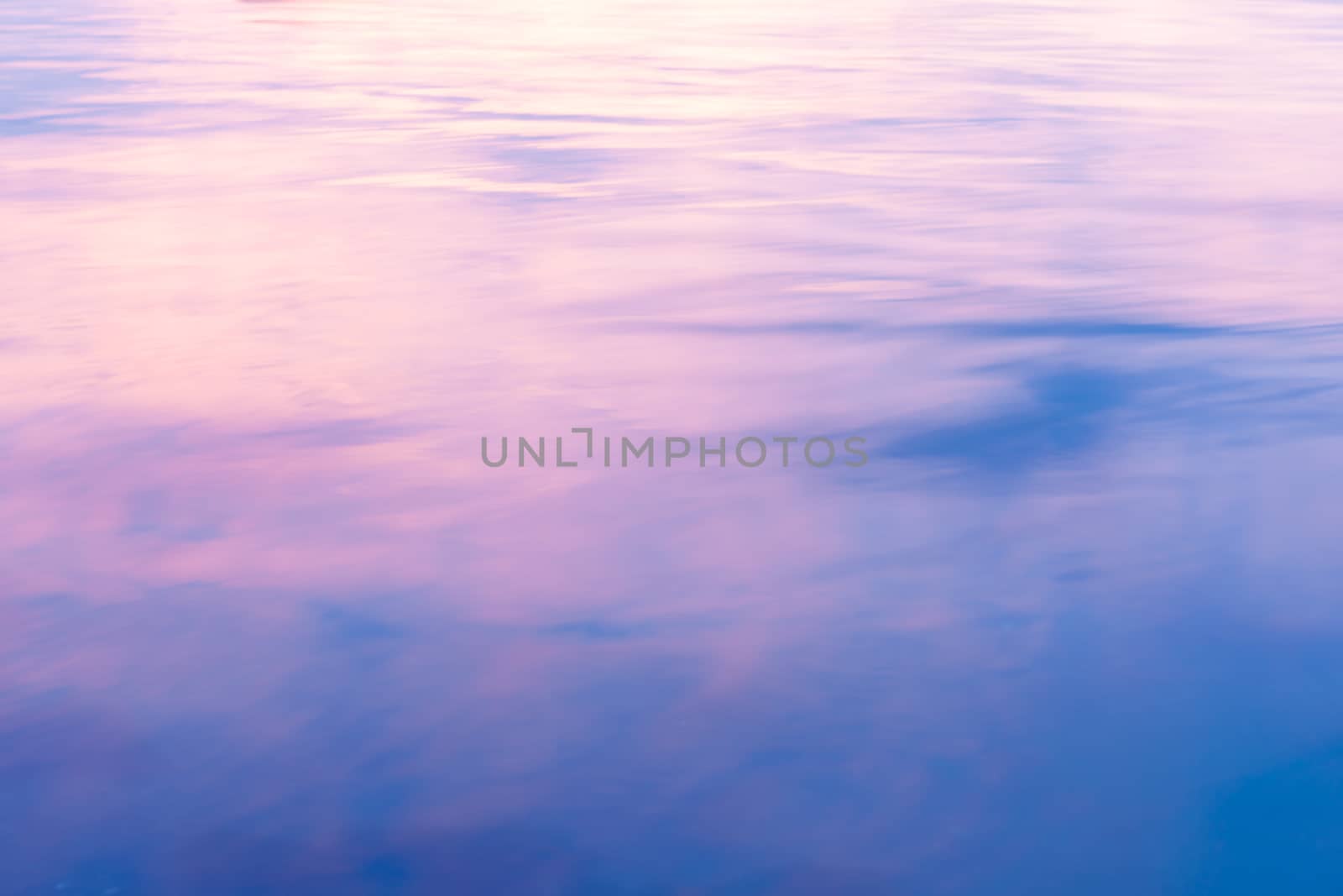 Abstract background. light on water as colors of clouds at sunset reflect.