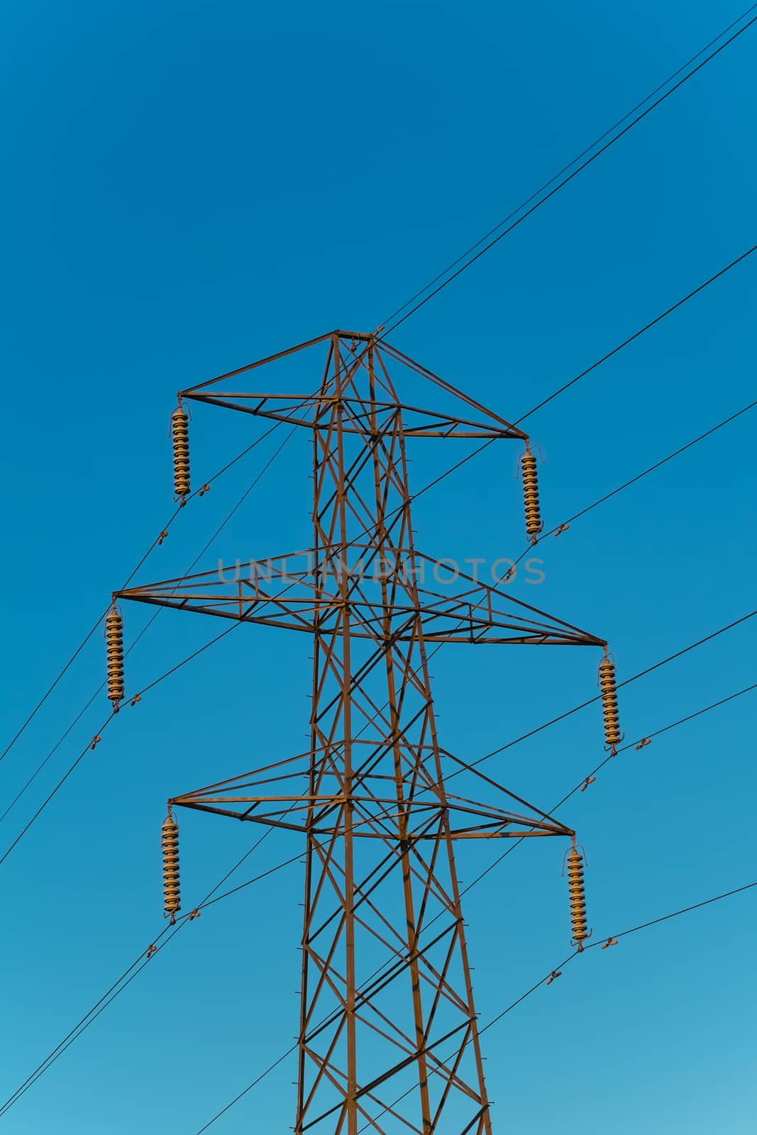 electricity pylon with six arms against a blue sky