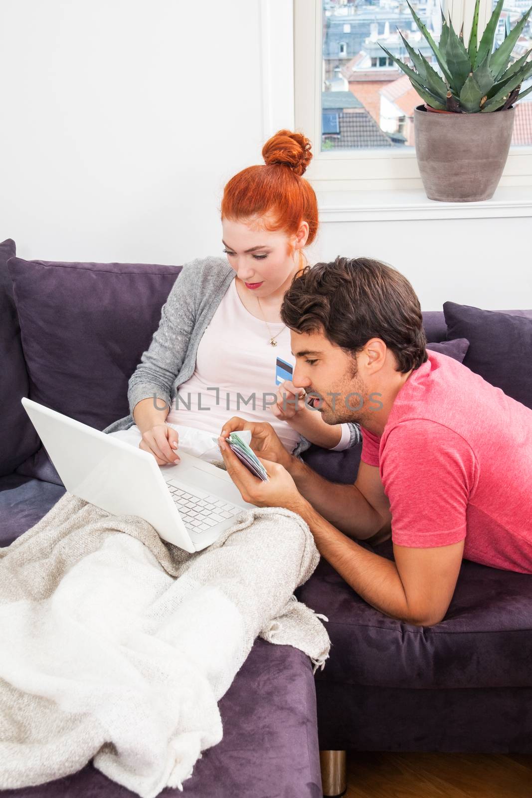 Sweet Young Couple Relaxing on the Couch in the Living Room, Watching a Movie on Laptop Computer Together.