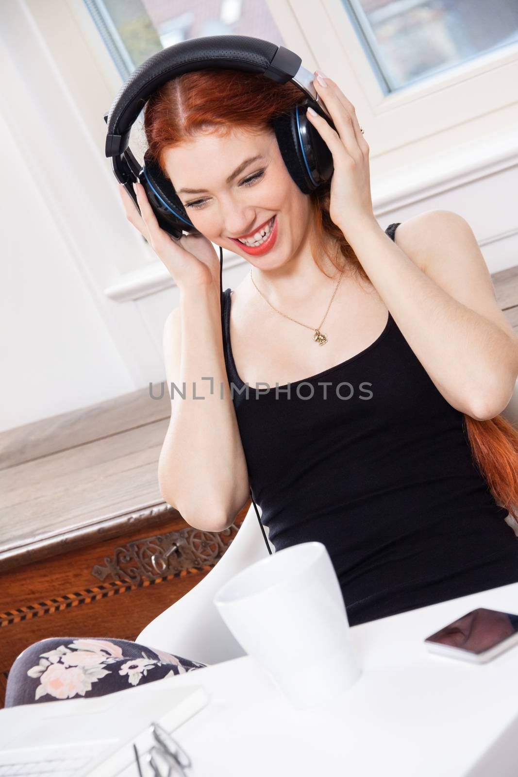 Happy Young Pretty Woman Laughing While Listening Funny Music Using Headphone Inside her Room.