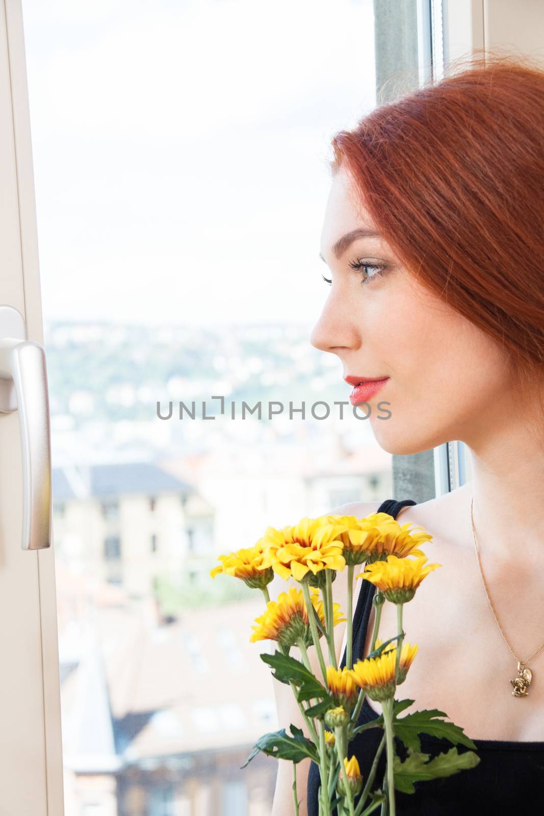 Close up Thoughtful Pretty Young Woman Holding Yellow Flowers, Looking Outside While Leaning on Glass Window.