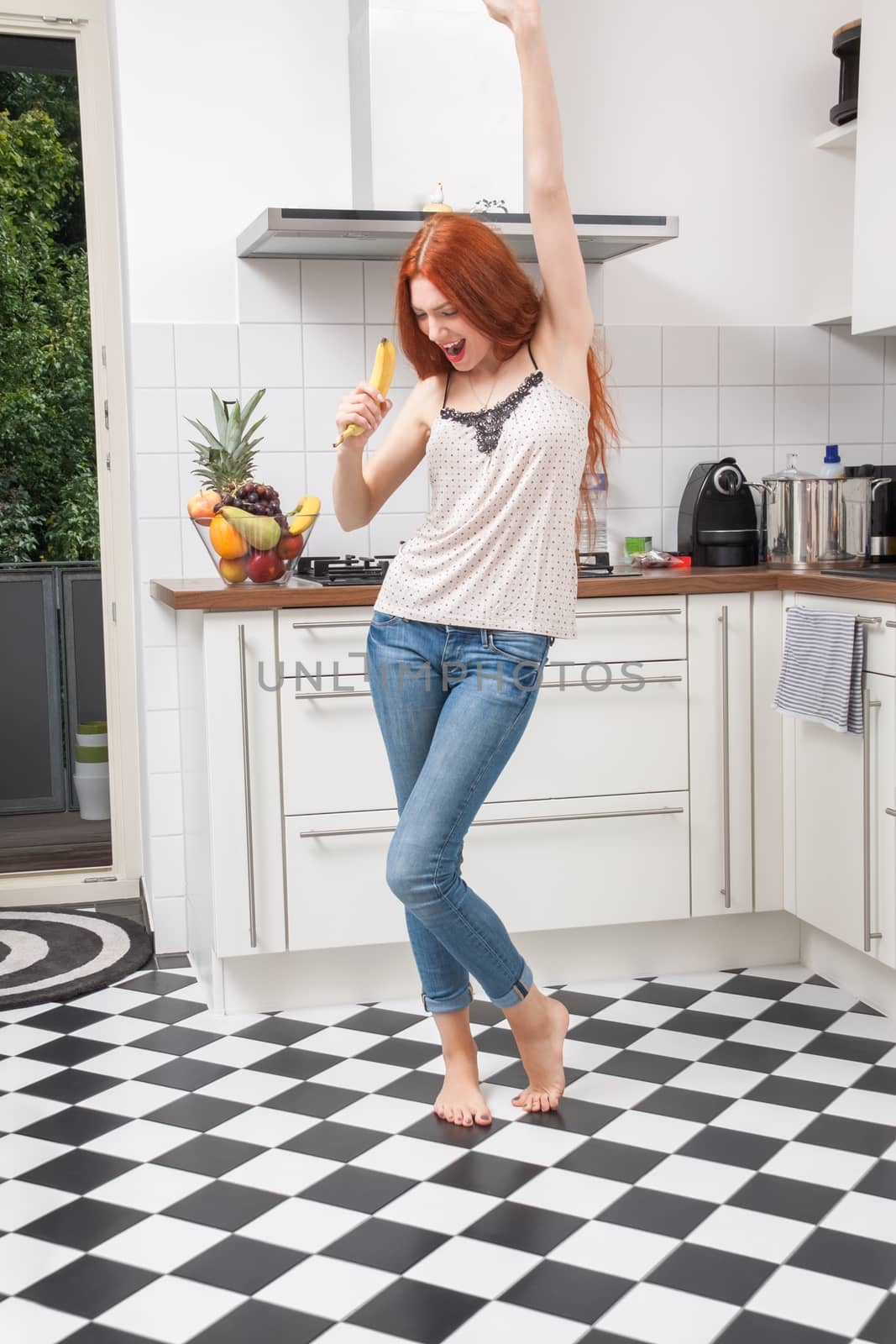 Happy Woman Holding Banana Dancing in the Kitchen by juniart