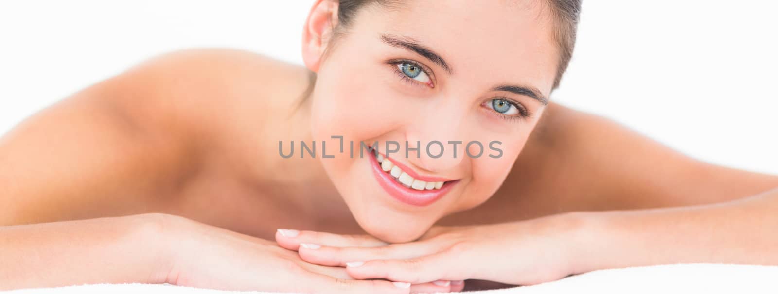 A portrait smiling pretty brunette on massage table by Wavebreakmedia