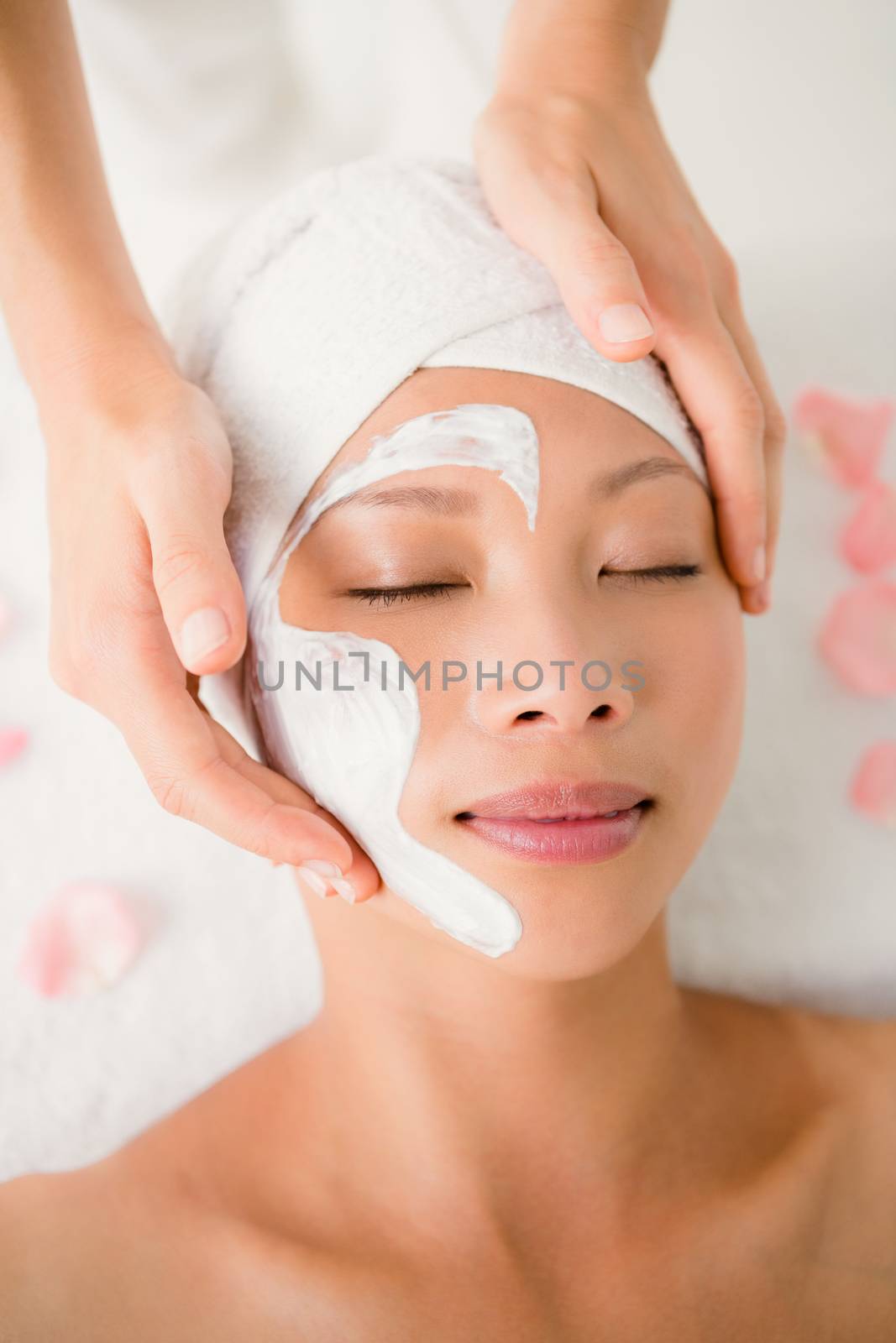 Close up of hands massaging a beautiful womans face at beauty spa