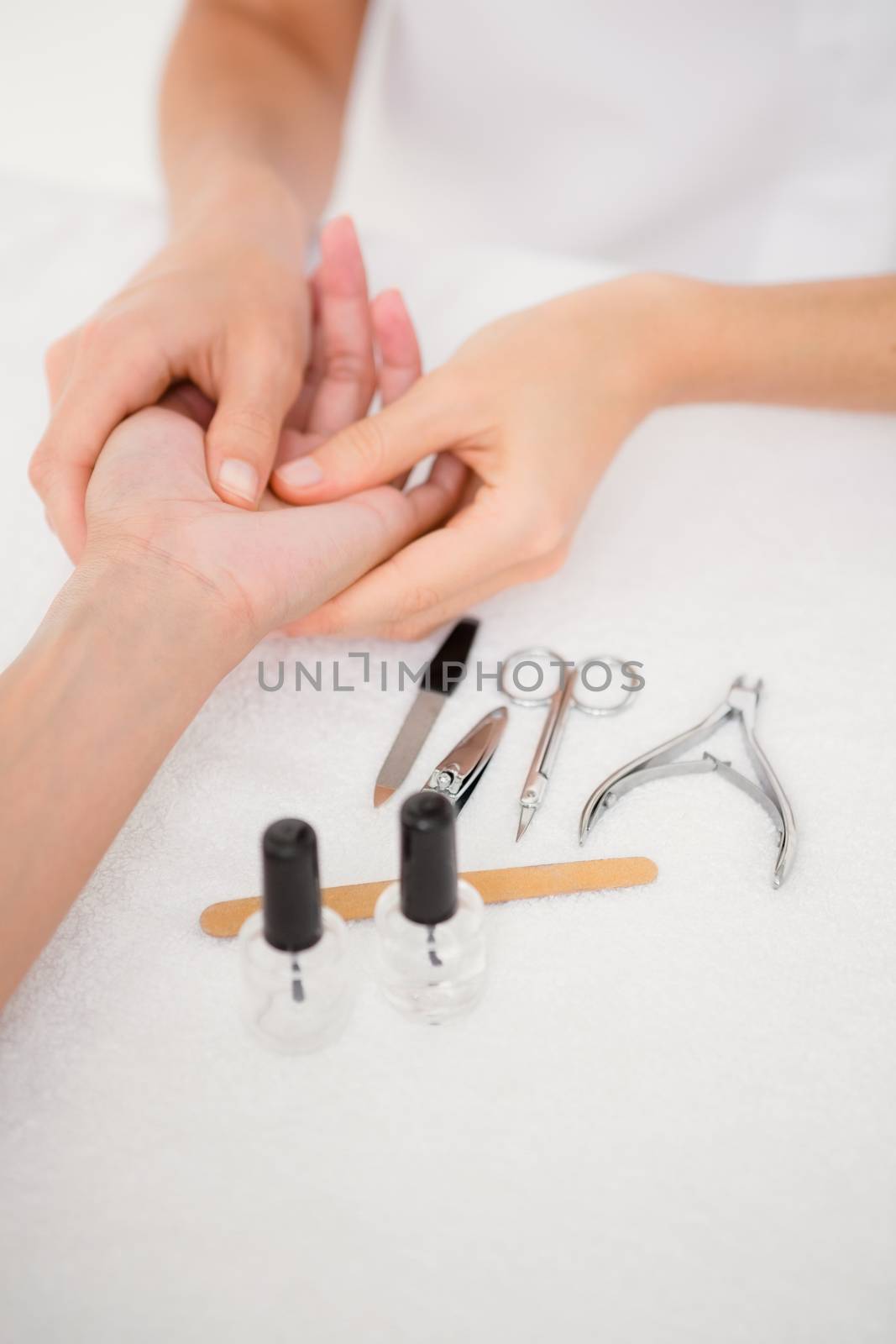 Close up of beautician filing female clients nails at spa beauty salon