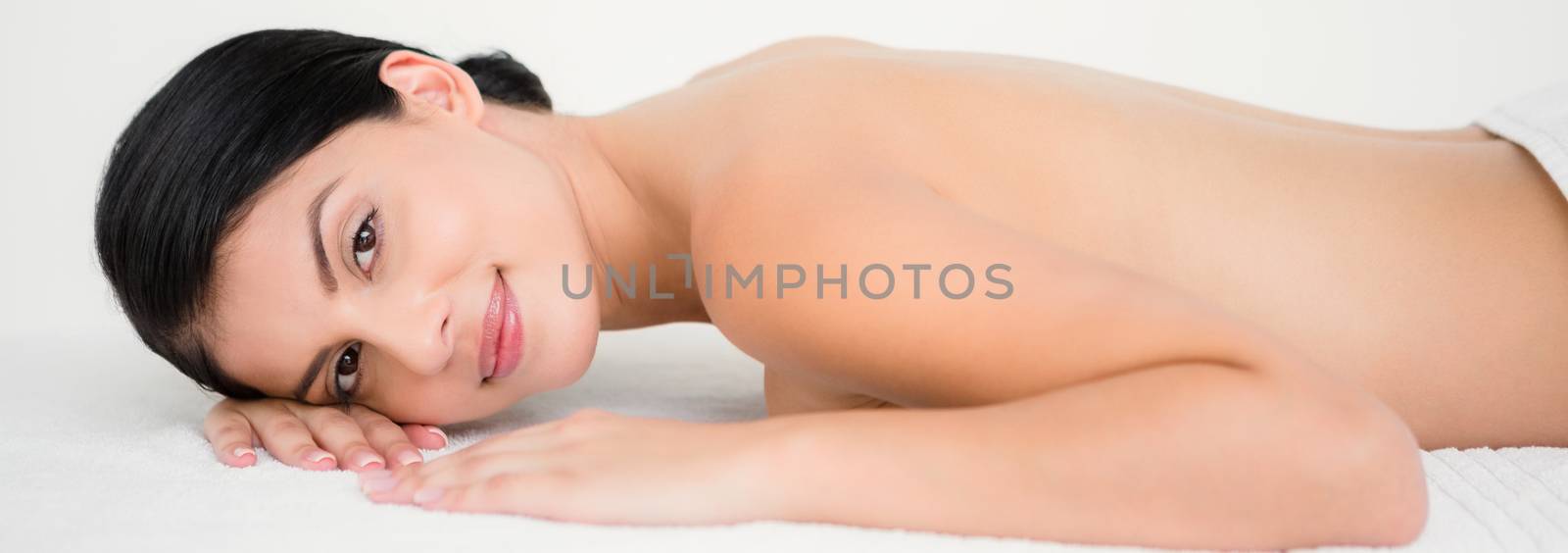 Pretty brunette enjoying a massage at camera at the health spa