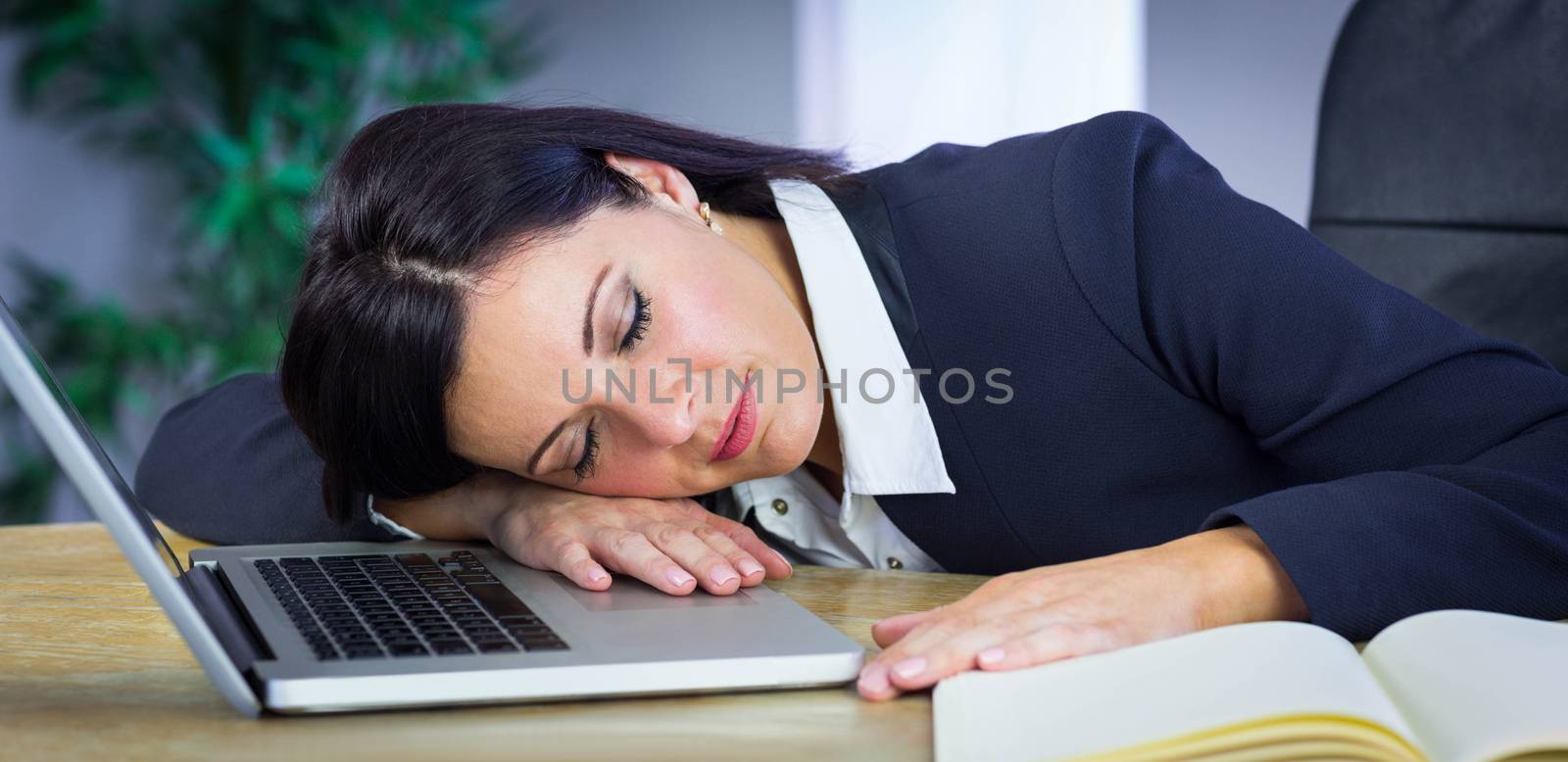 Businesswoman taking a nap on her desk in her office